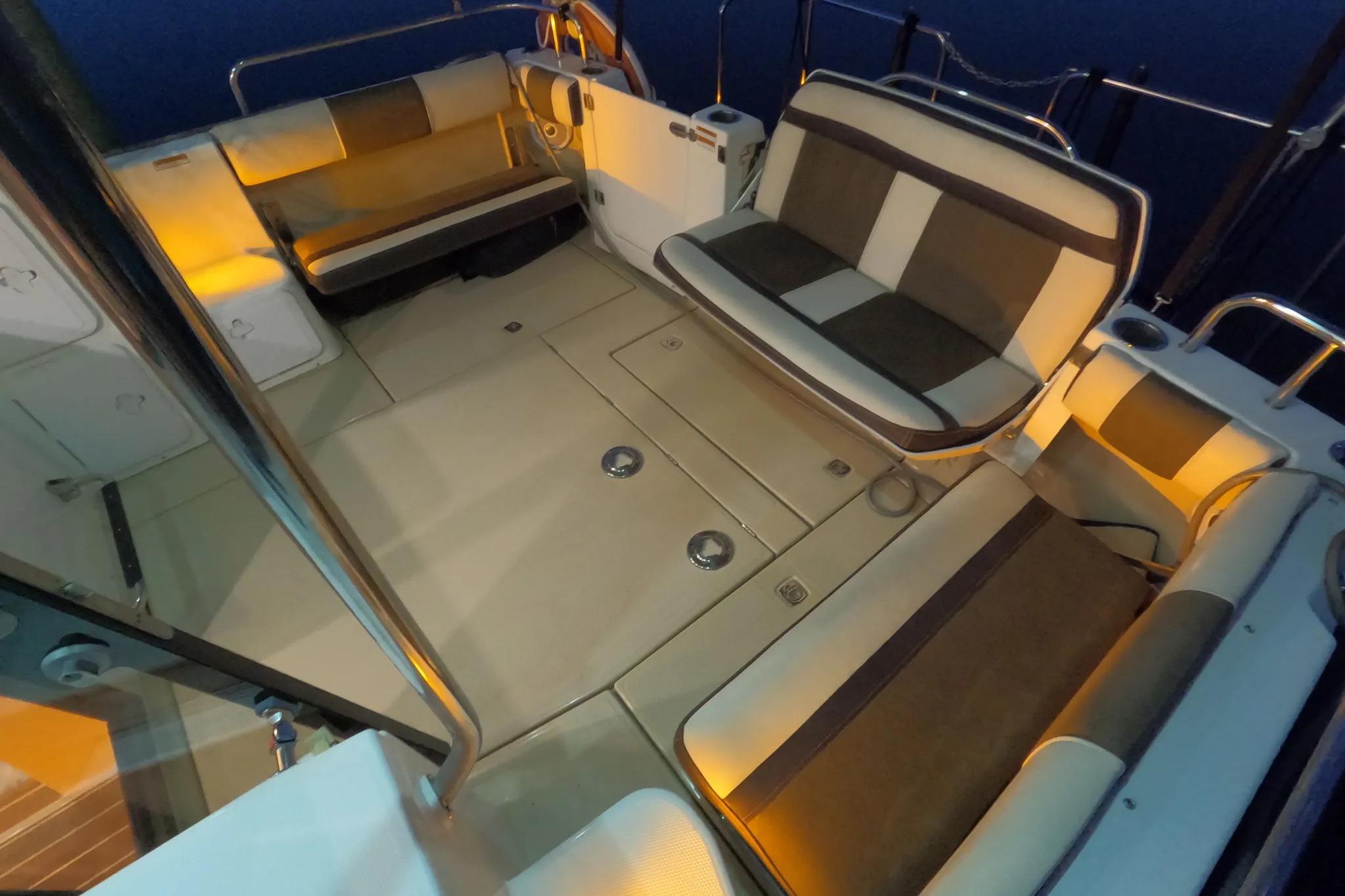 2015 Ranger Tugs R-29 S boat interior with cushioned seating and ambient lighting.