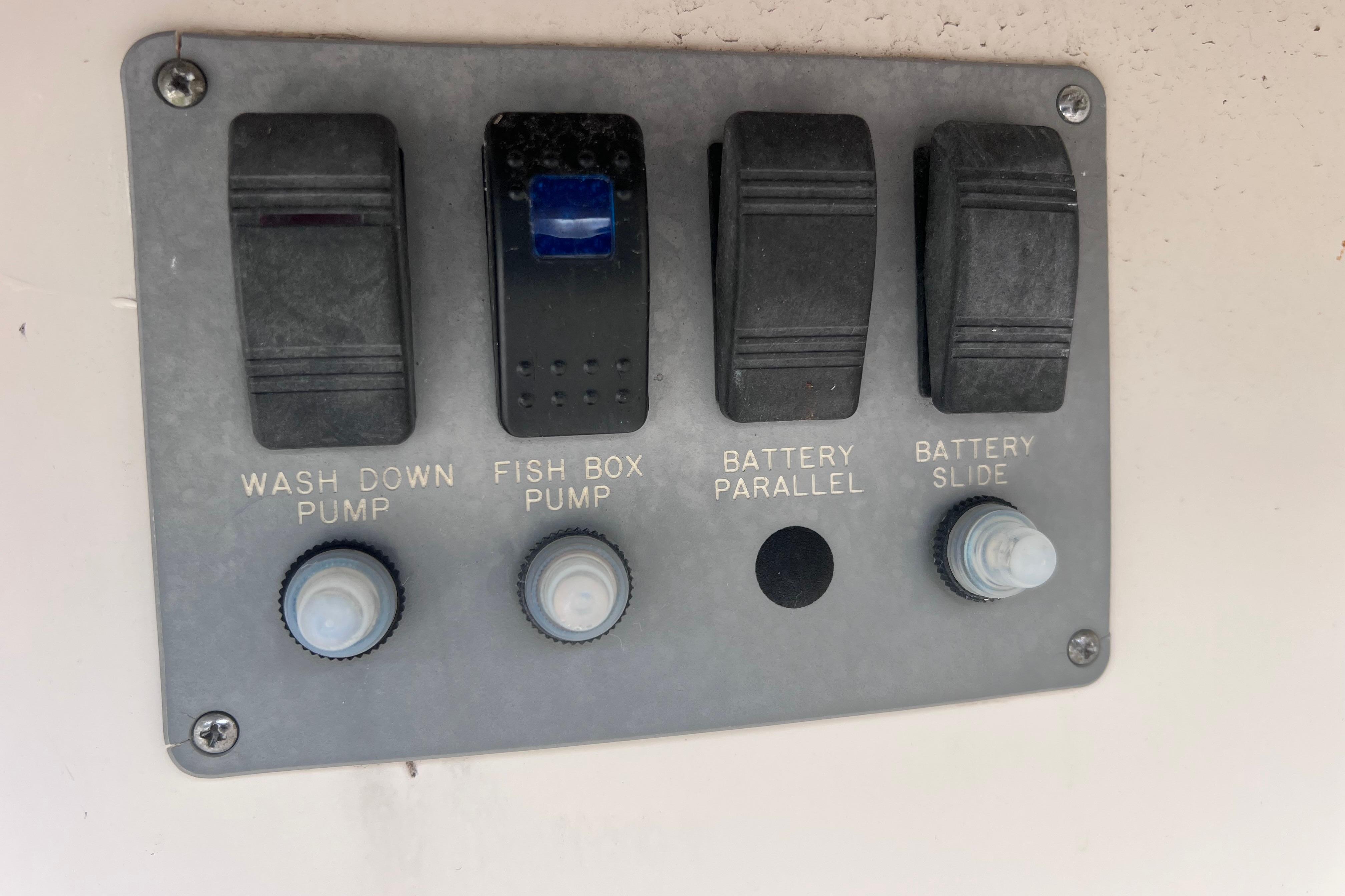 Control panel on a 2005 Pursuit 3070 Offshore boat with pump and battery switches.