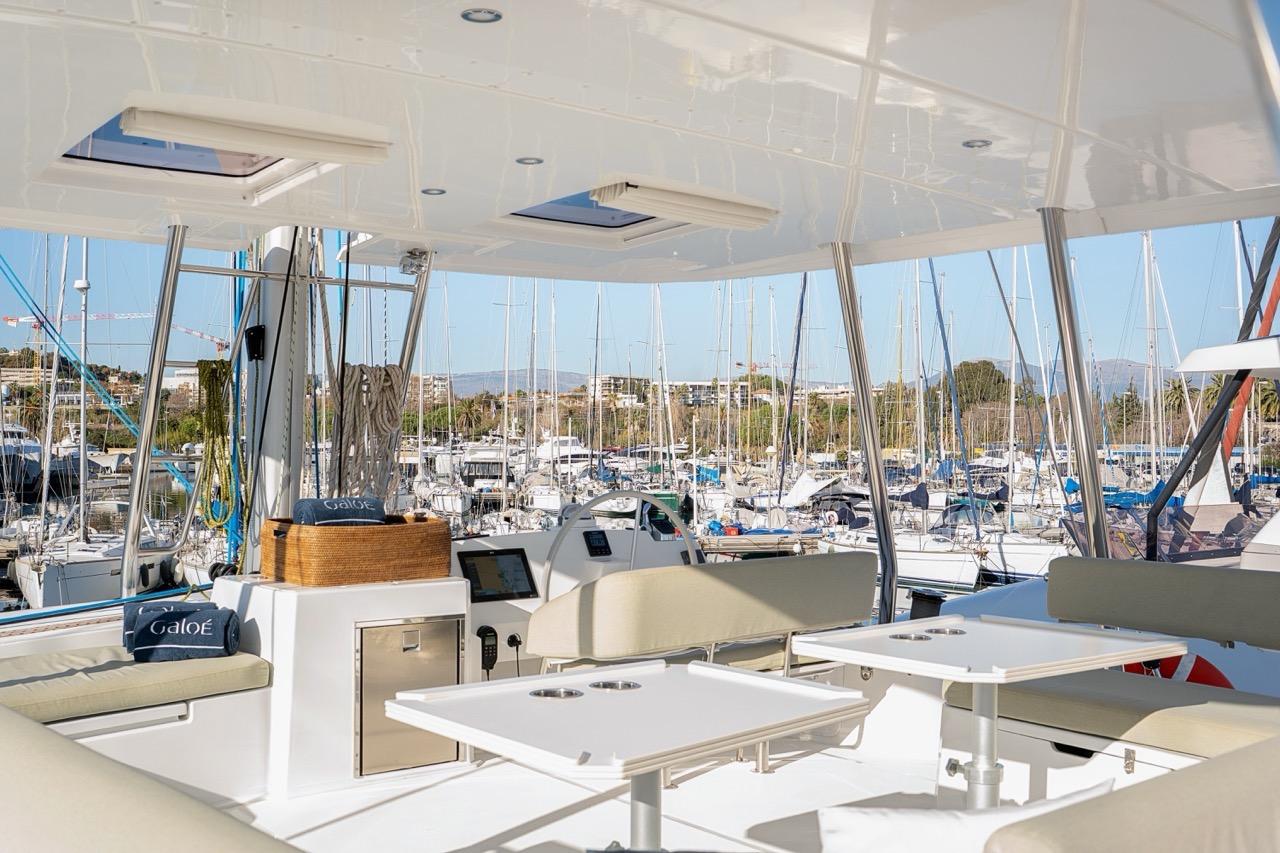 Luxurious 2023 Bali 5.4 yacht interior with marina view, featuring comfortable seating and modern design.