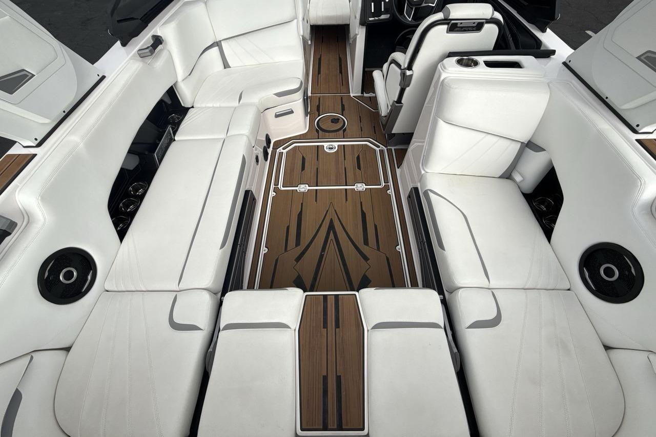Luxurious interior of 2024 Supra SA 550 boat with white seating and wood accents.
