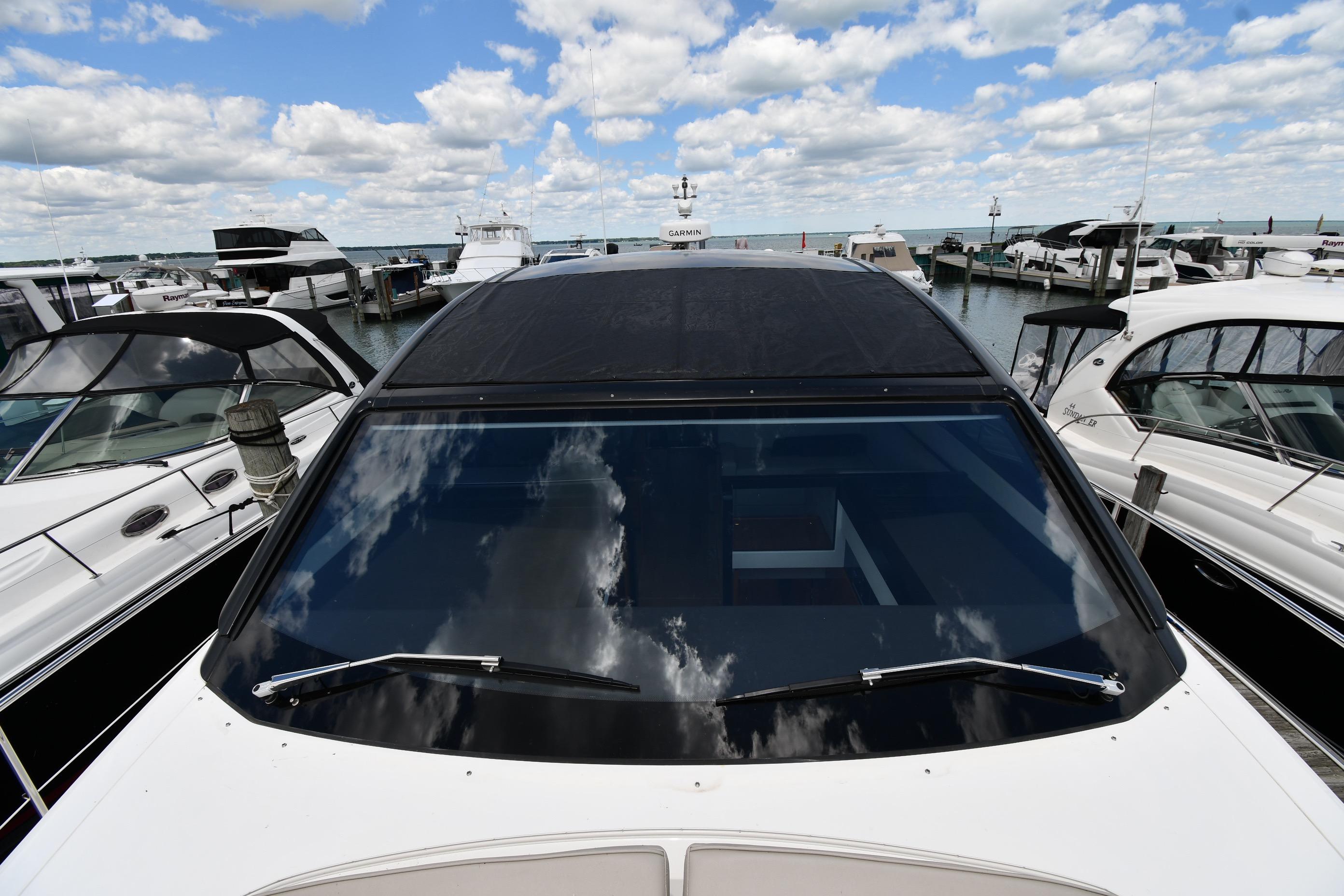 2024 Fairline G50 Targa yacht docked at marina under partly cloudy sky.