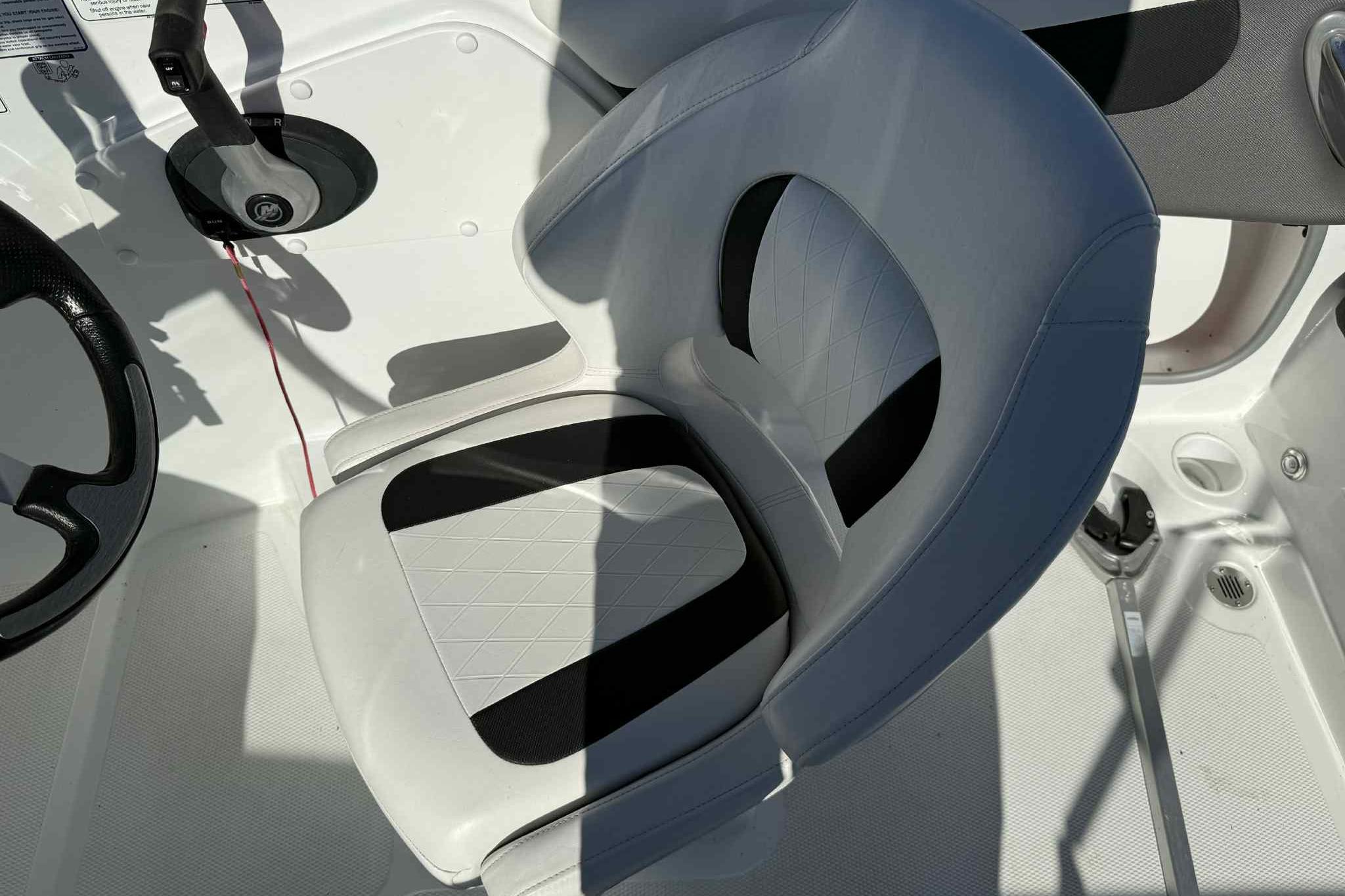 2021 Tahoe 550 TS boat interior with steering wheel and cushioned seat.