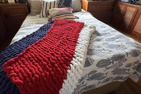 Cozy cabin bed with nautical-themed decor on a 1980 Viking 43 Convertible.