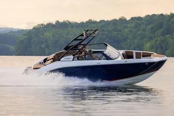 2026 Yamaha Boats 222SE cruising on a serene lake with lush green backdrop.