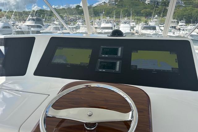 Helm of 2007 Viking 52 Convertible yacht with navigation screens in marina setting.