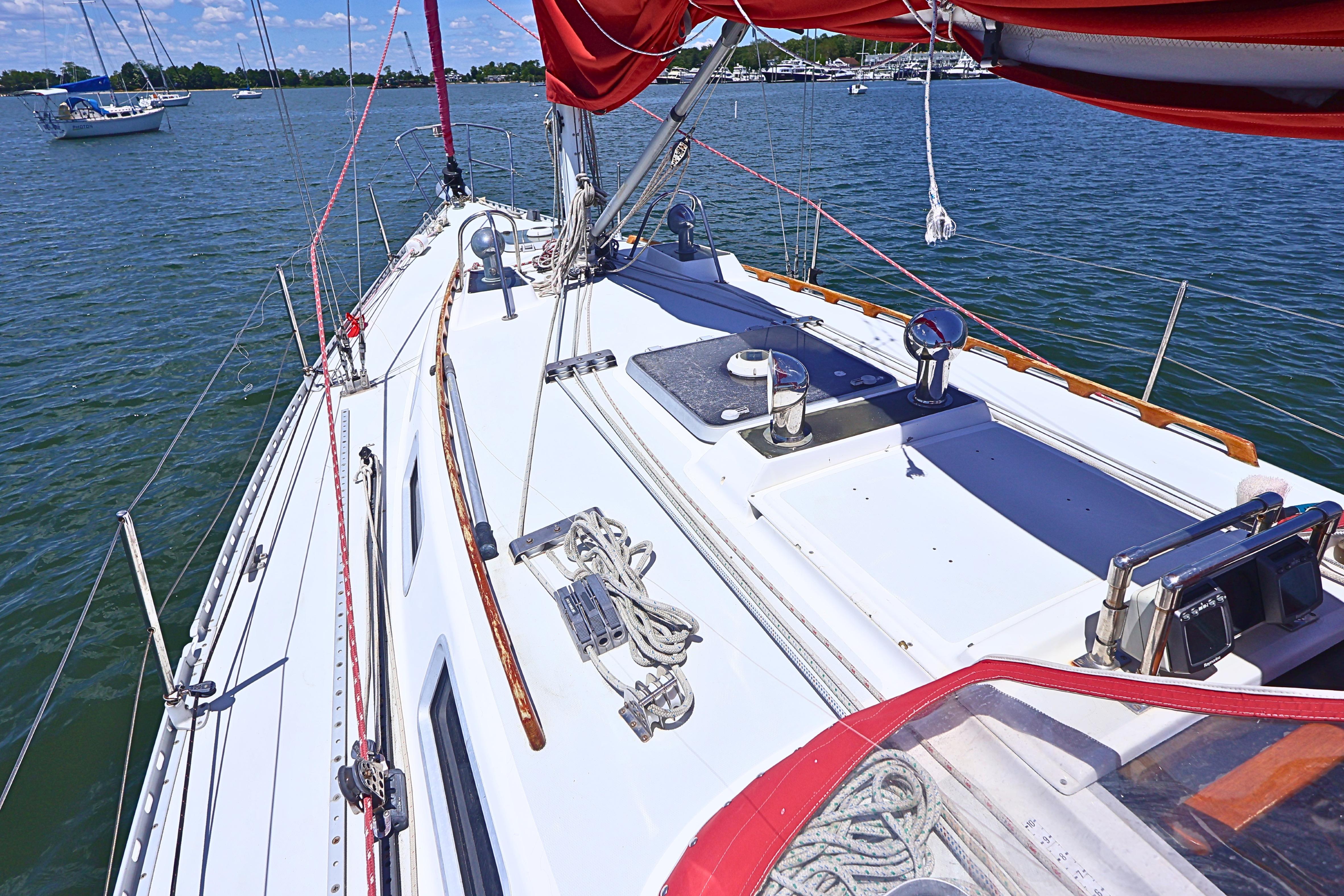 1989 J Boat J 40 sailboat deck with red sails on calm water.