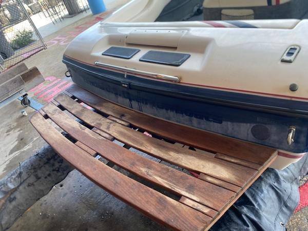 1998 Malibu Response boat with wooden swim platform, parked on a trailer.