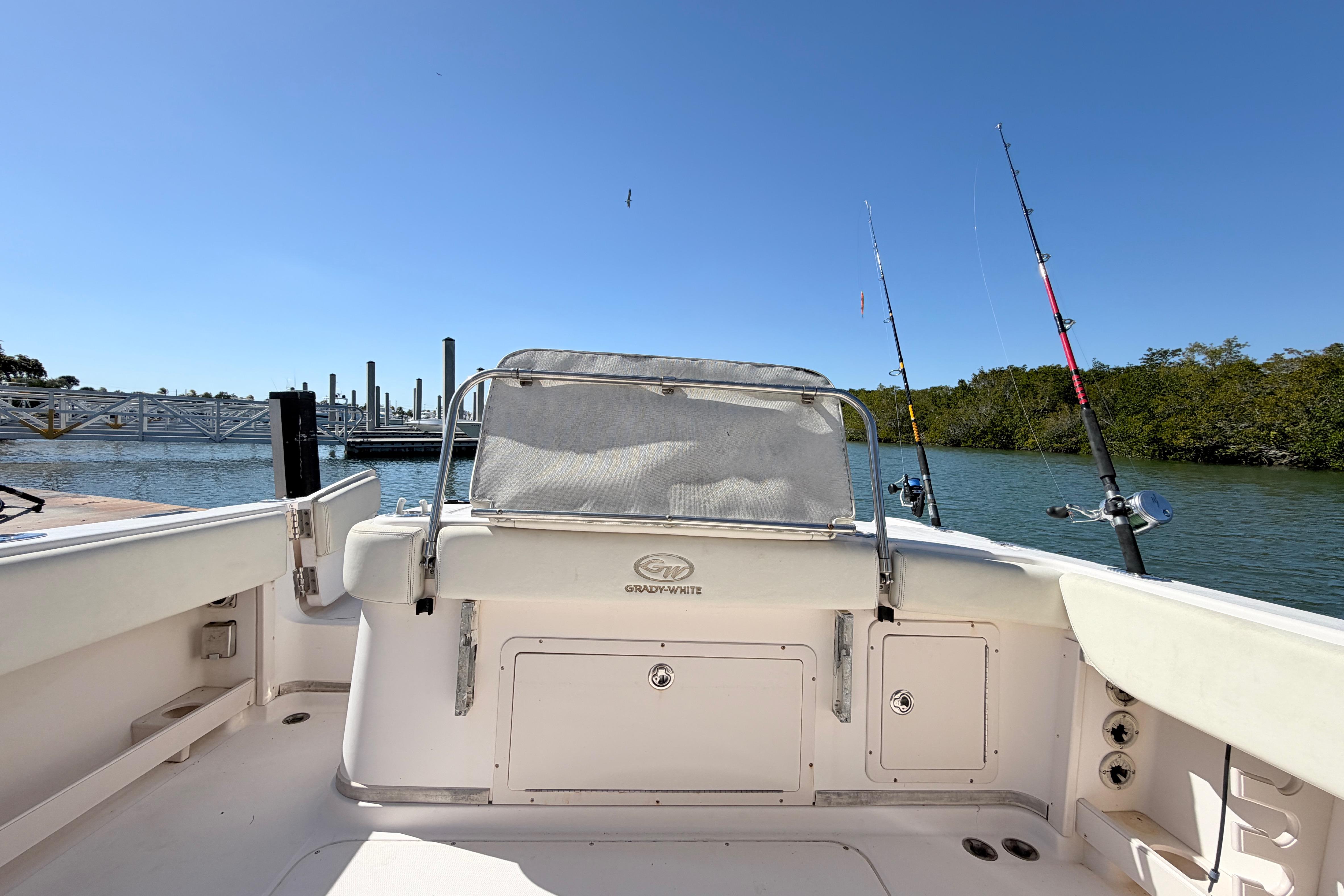 2006 Grady-White Sailfish 282 boat with fishing rods, docked by a serene waterfront.