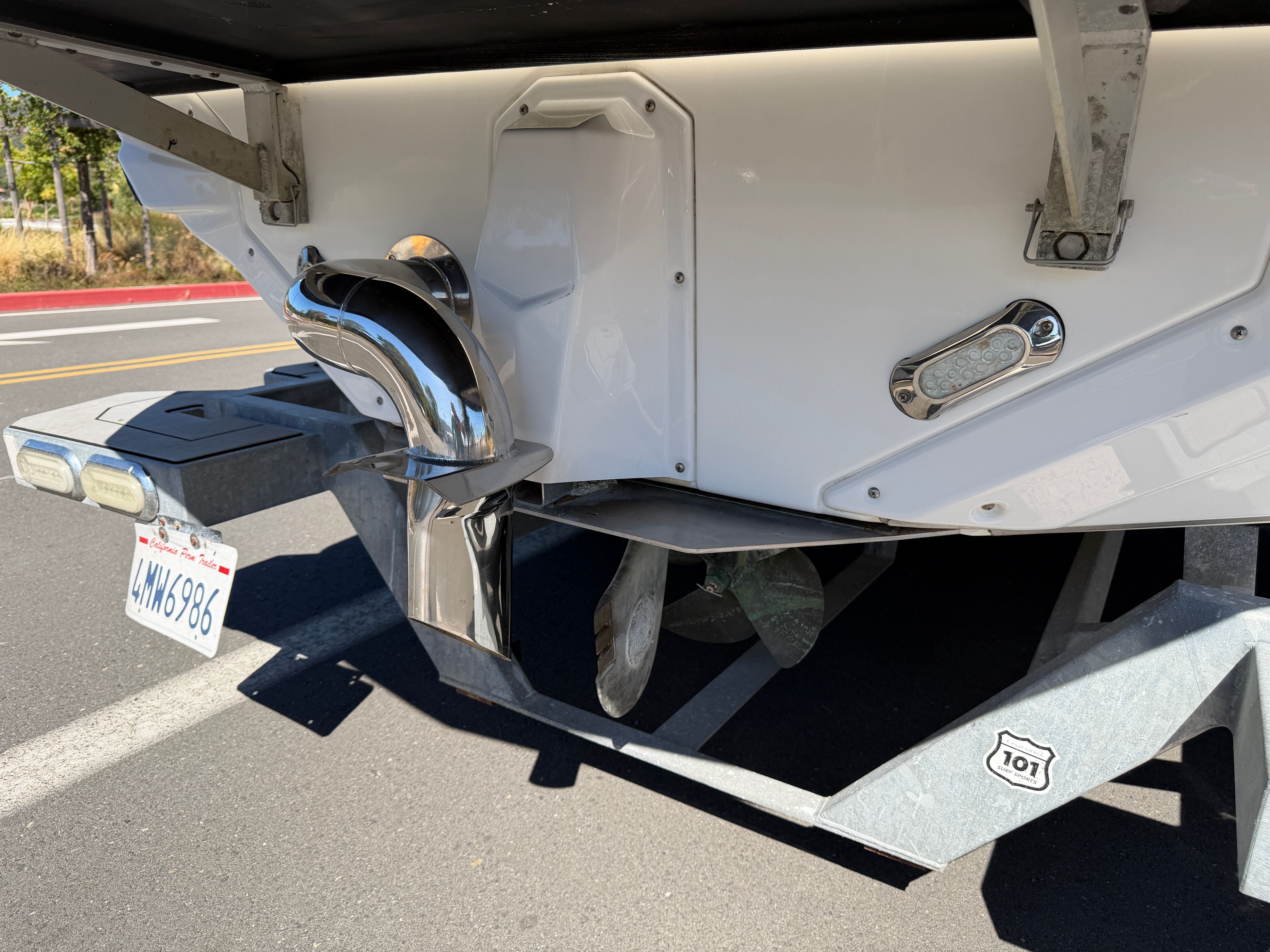 Rear view of a boat trailer with propeller and exhaust.