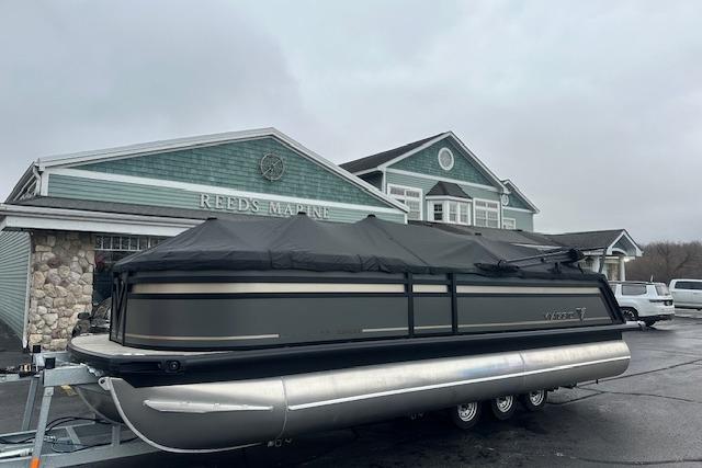 2026 Viaggio Lago Z-Q pontoon boat covered, parked at Reeds Marine dealership.