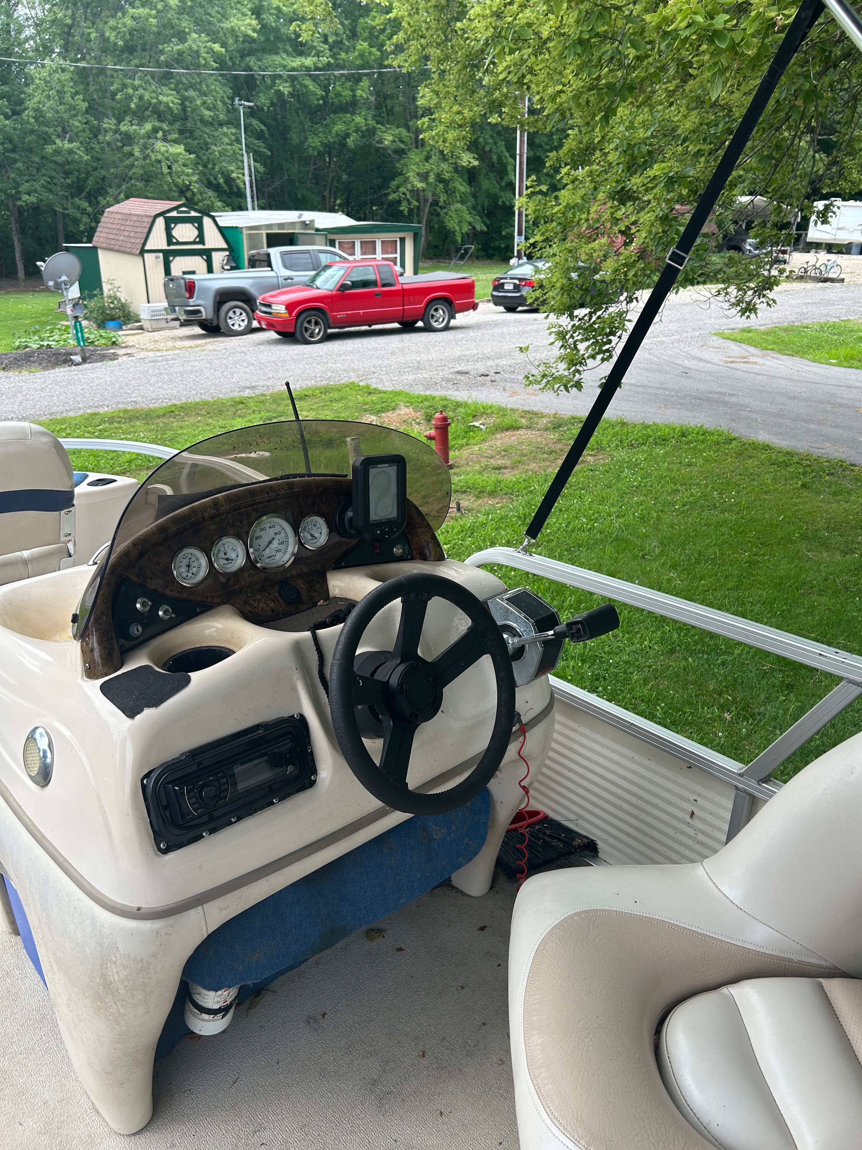 The image shows the helm of a 2008 Sun Tracker Fishin' Barge 21', parked on grass.