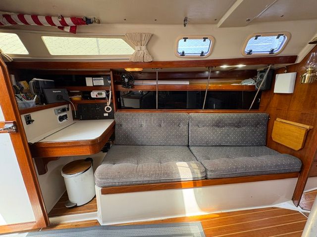 Interior of a 1989 Catalina 34 with a gray sofa and wooden elements.