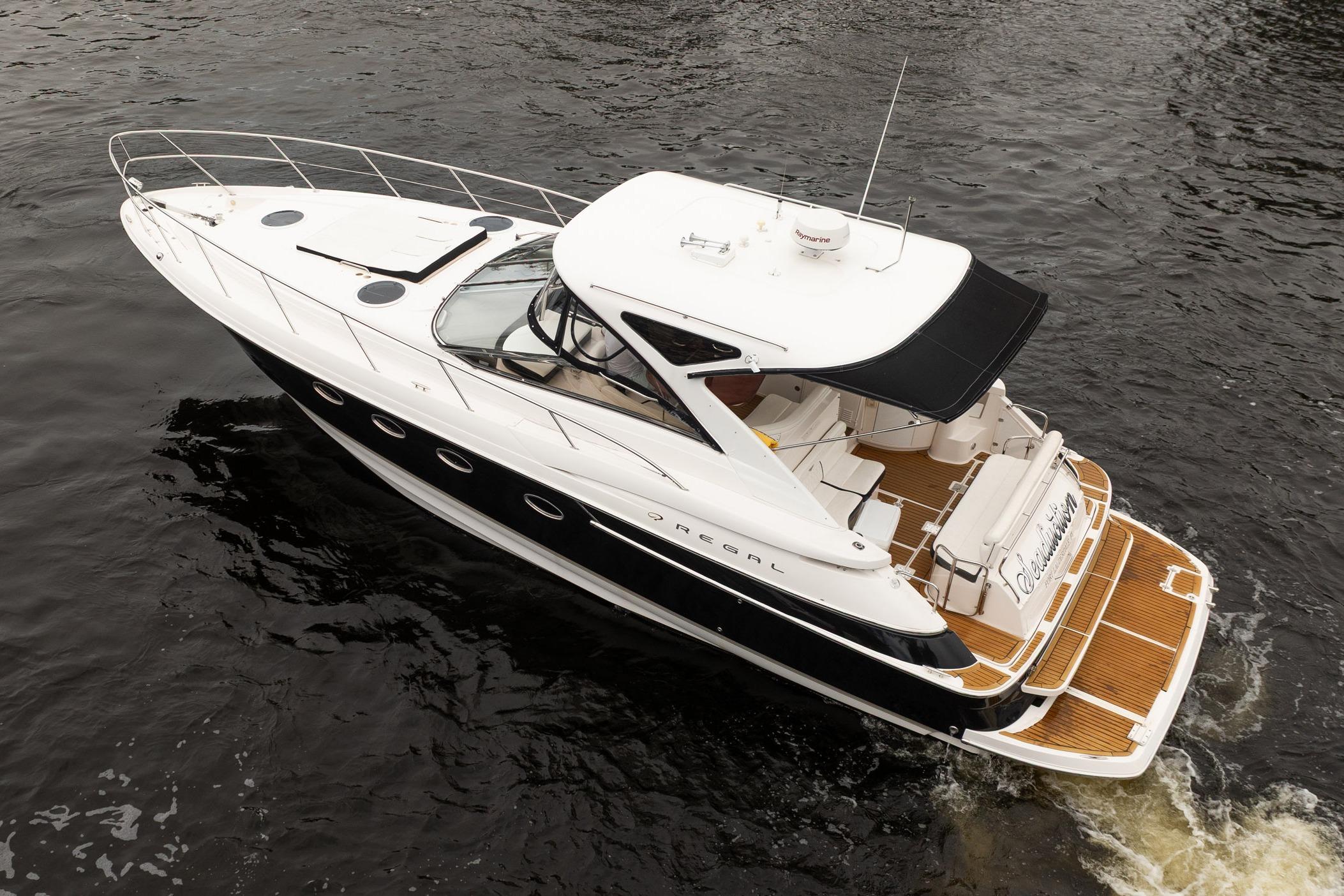 2008 Regal Commodore 4460 yacht cruising on water, featuring sleek design and spacious deck.