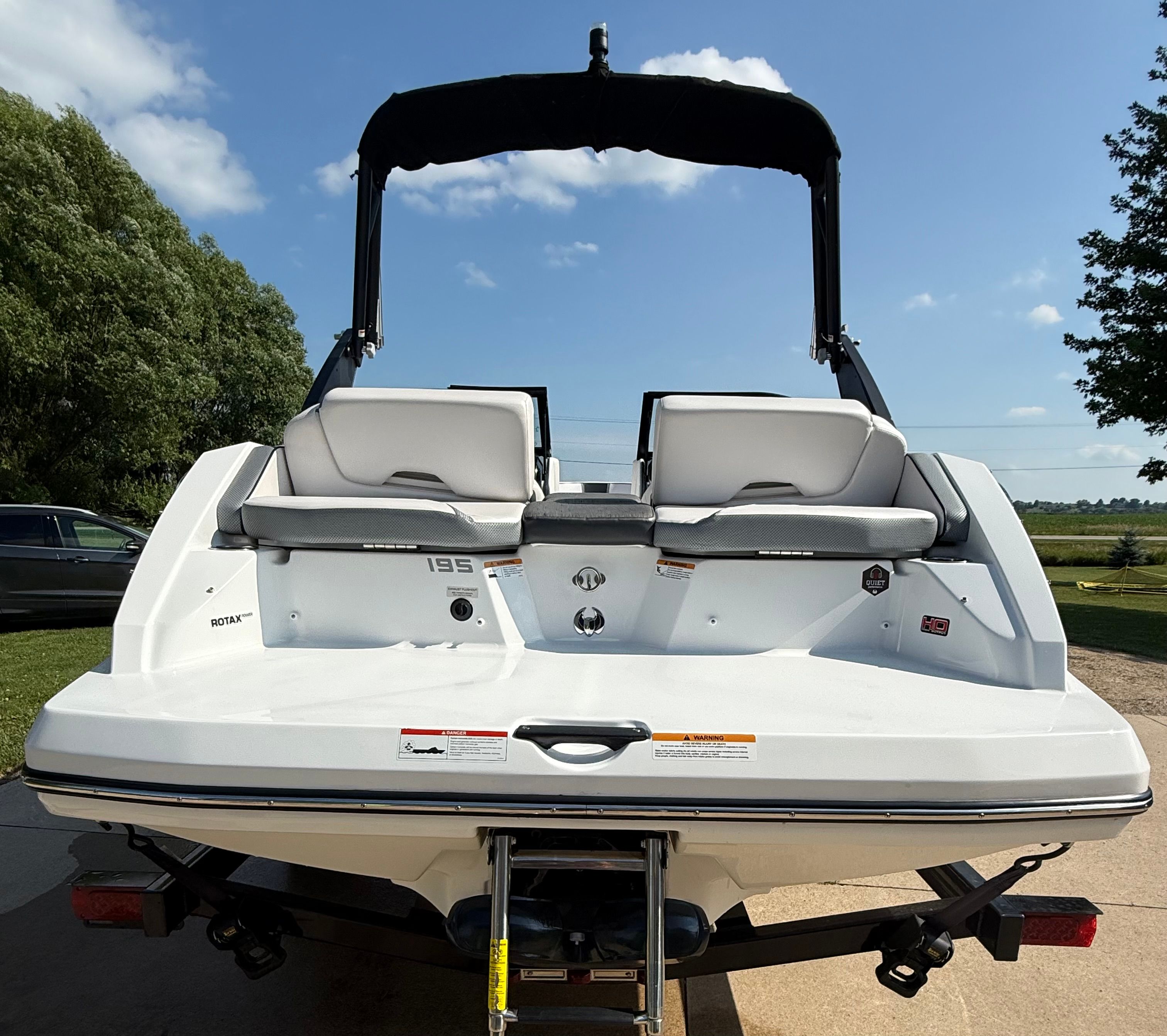 The image shows the rear of a 2023 Scarab 195 ID boat with two seats and a swim platform.