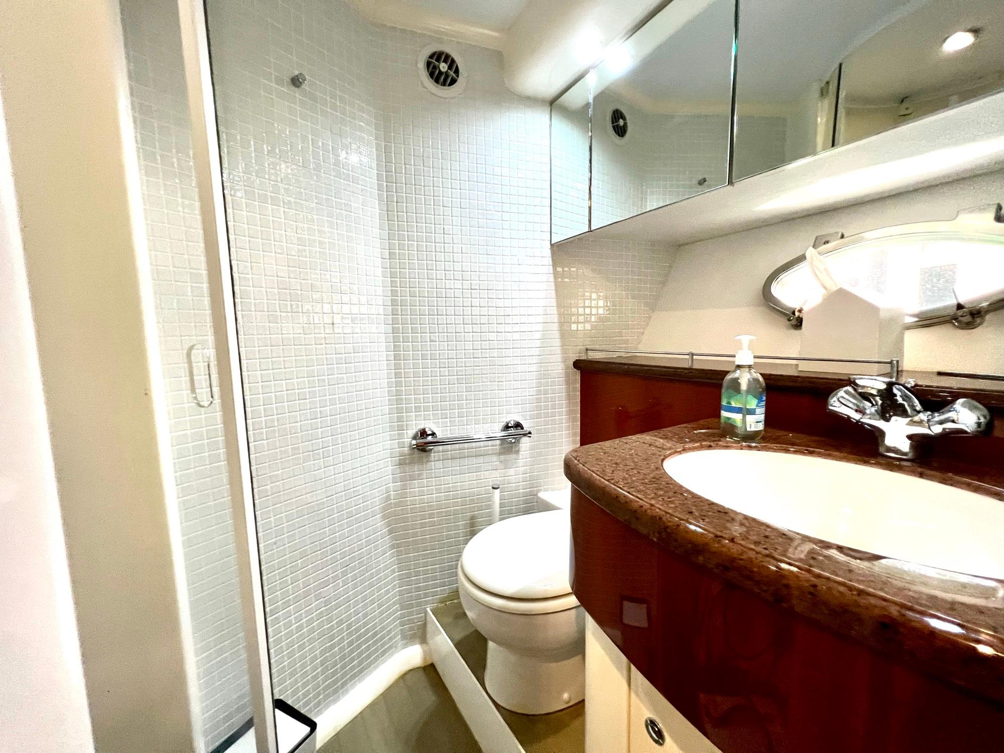 Luxurious bathroom in 1999 Fairline Squadron 65 yacht with modern fixtures and glass shower.