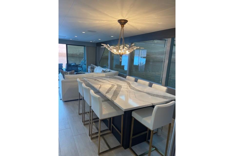 Luxurious dining area on Adonia's 2021 "The Queen Elizabeth" yacht with elegant chandelier.