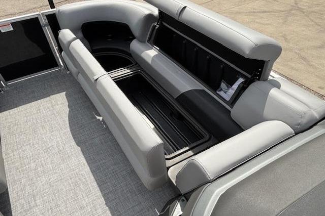 2026 Sun Tracker Party Barge 20 DLX interior with open storage compartment and gray seating.