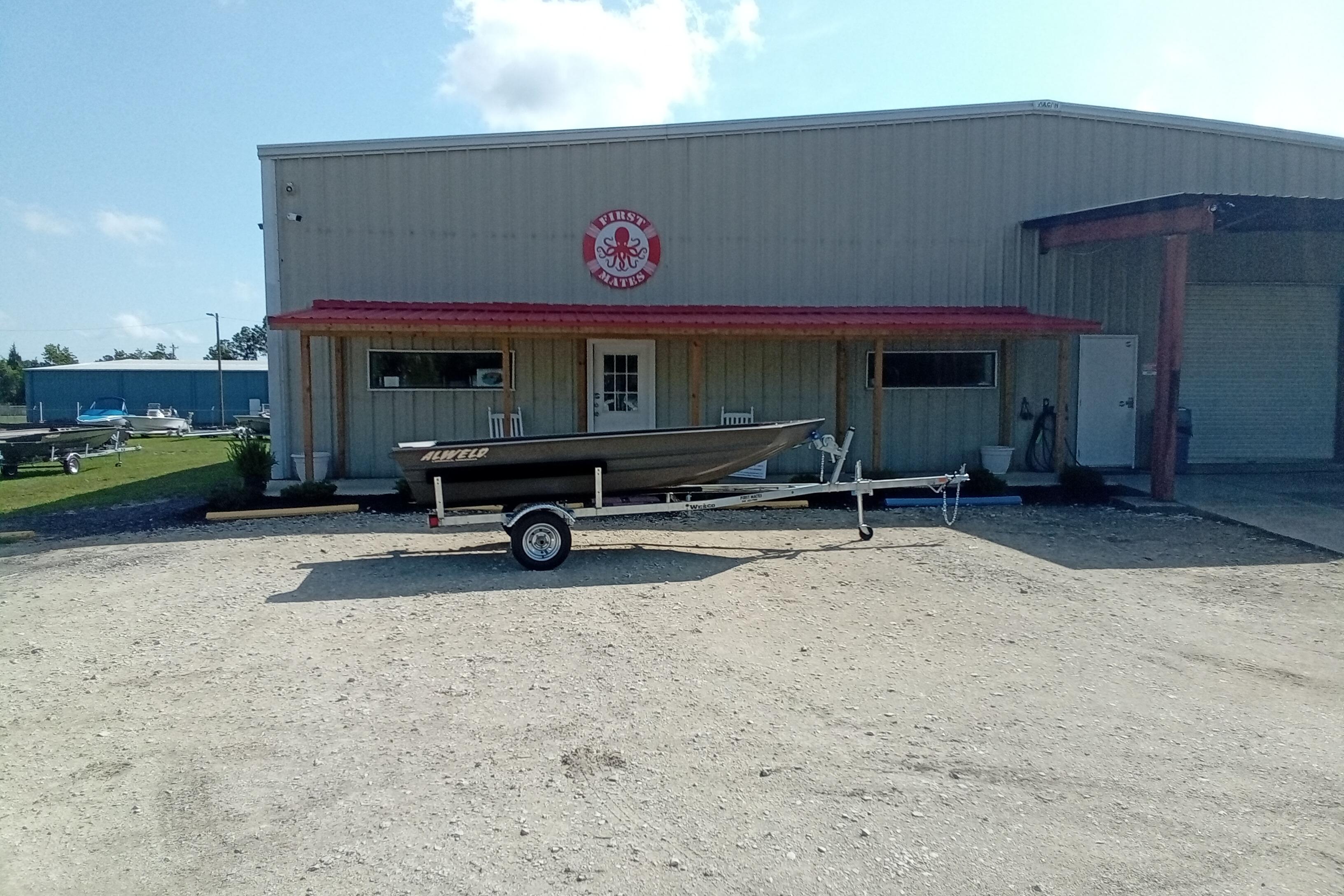 2026 Alweld 1448VV Vee Bottom boat on trailer outside a metal building.