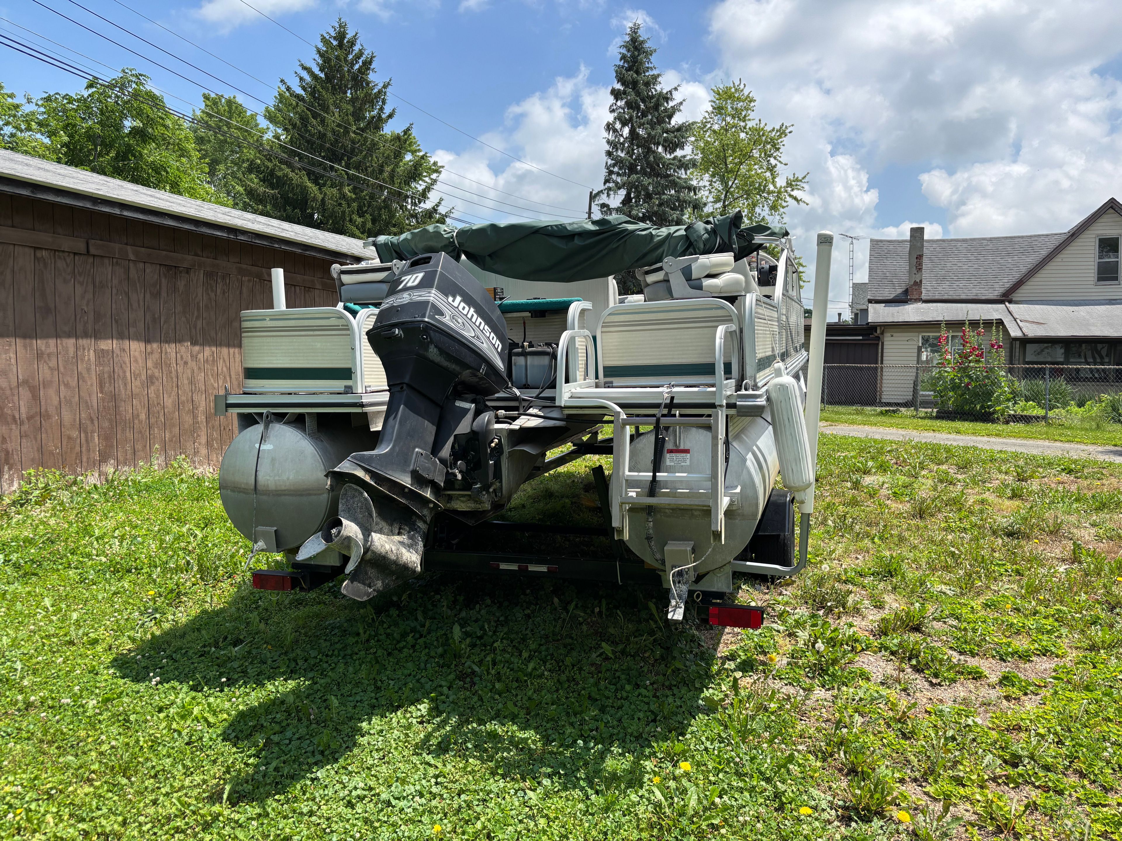 A 2001 Lowe Trinidad 204 pontoon boat is on a trailer outdoors.
