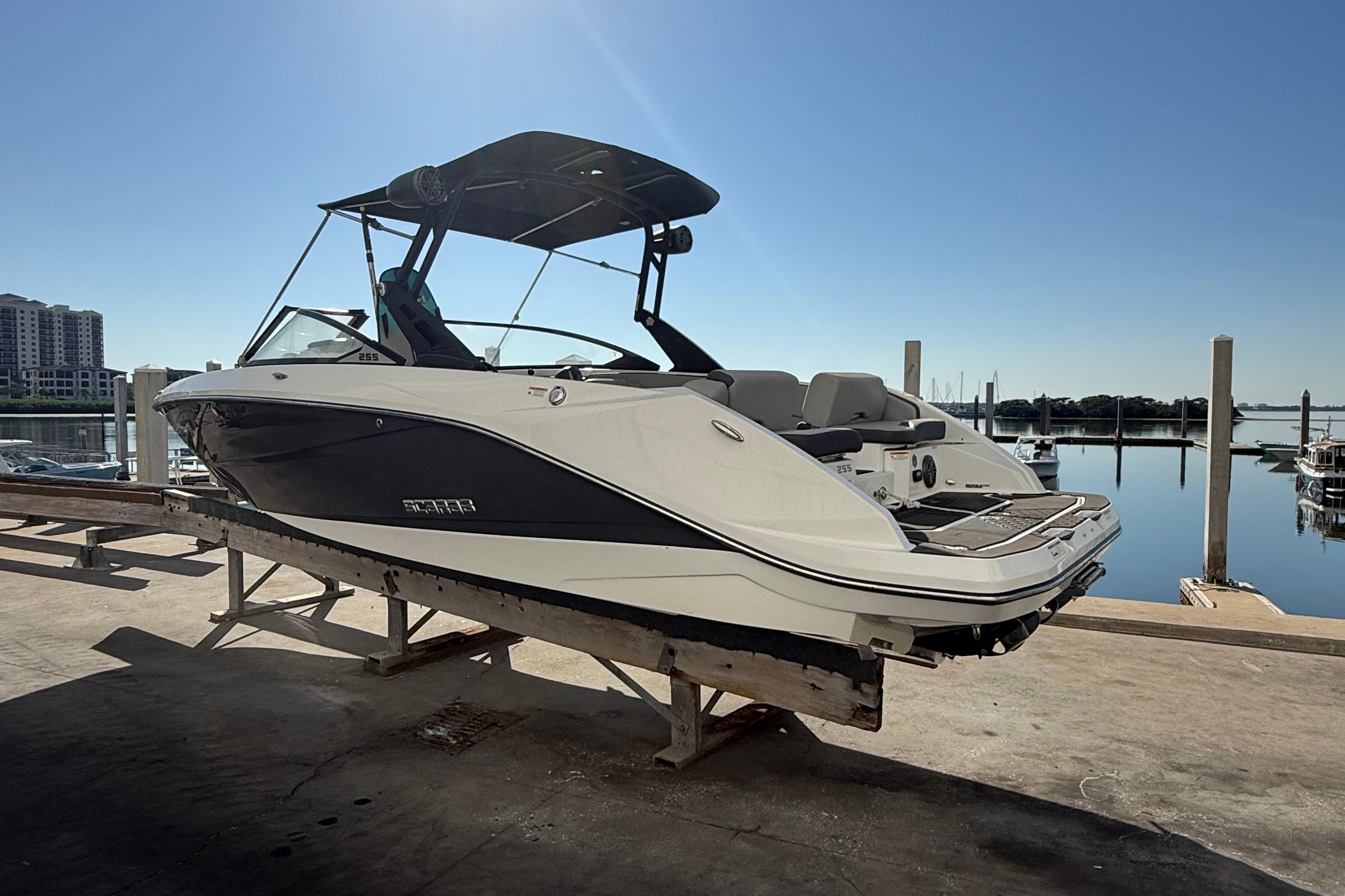 2021 Scarab 255 ID boat docked at marina under clear blue sky.