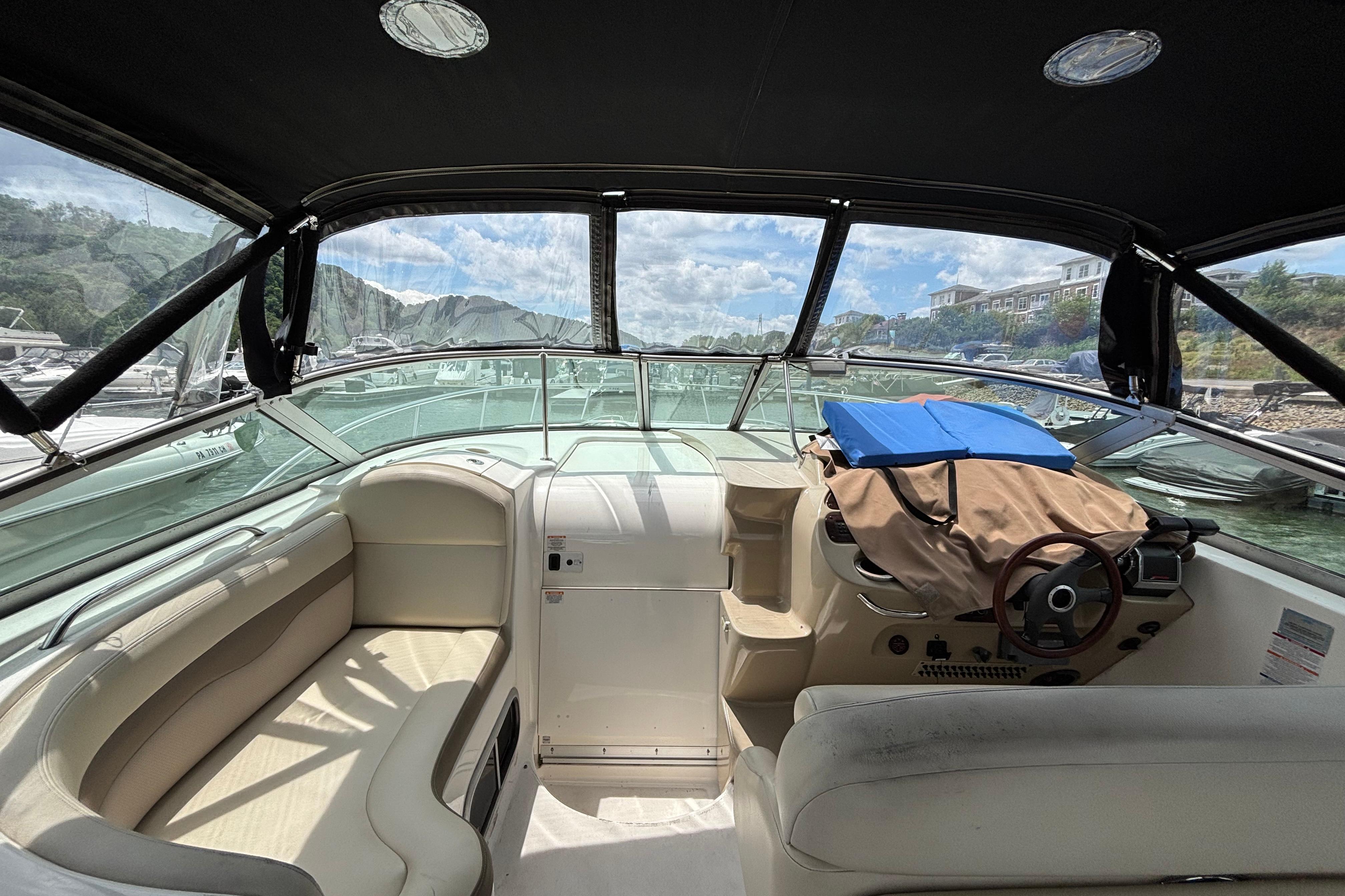 2004 Chaparral Signature 330 boat interior with seating and steering wheel, docked at marina.