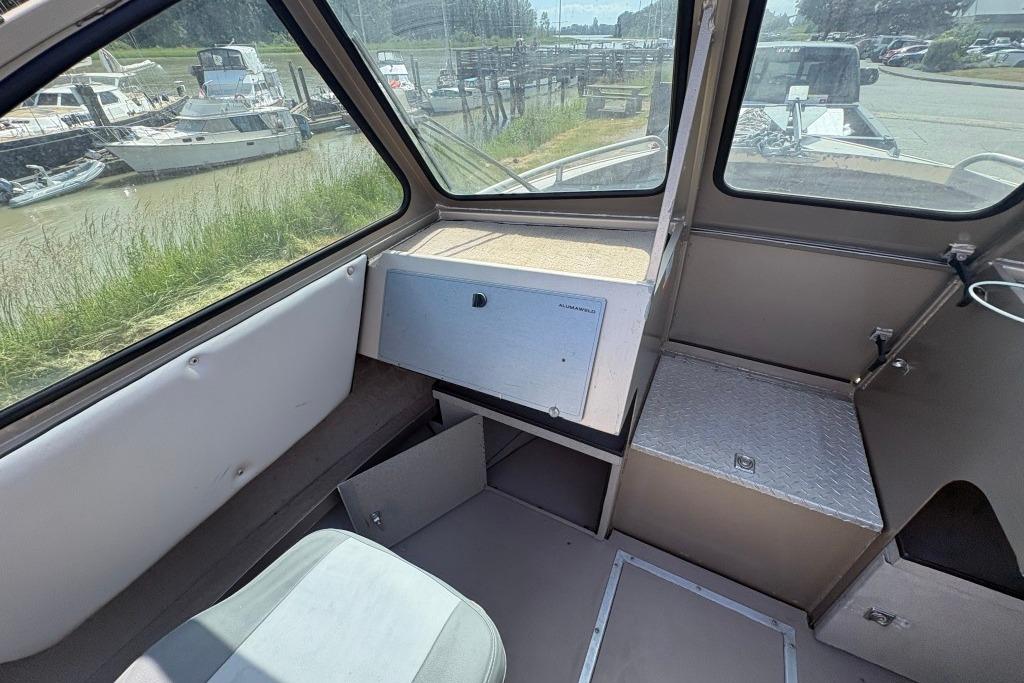 Interior of a 2009 Alumaweld Intruder Outboard 22 boat, featuring seating and storage.