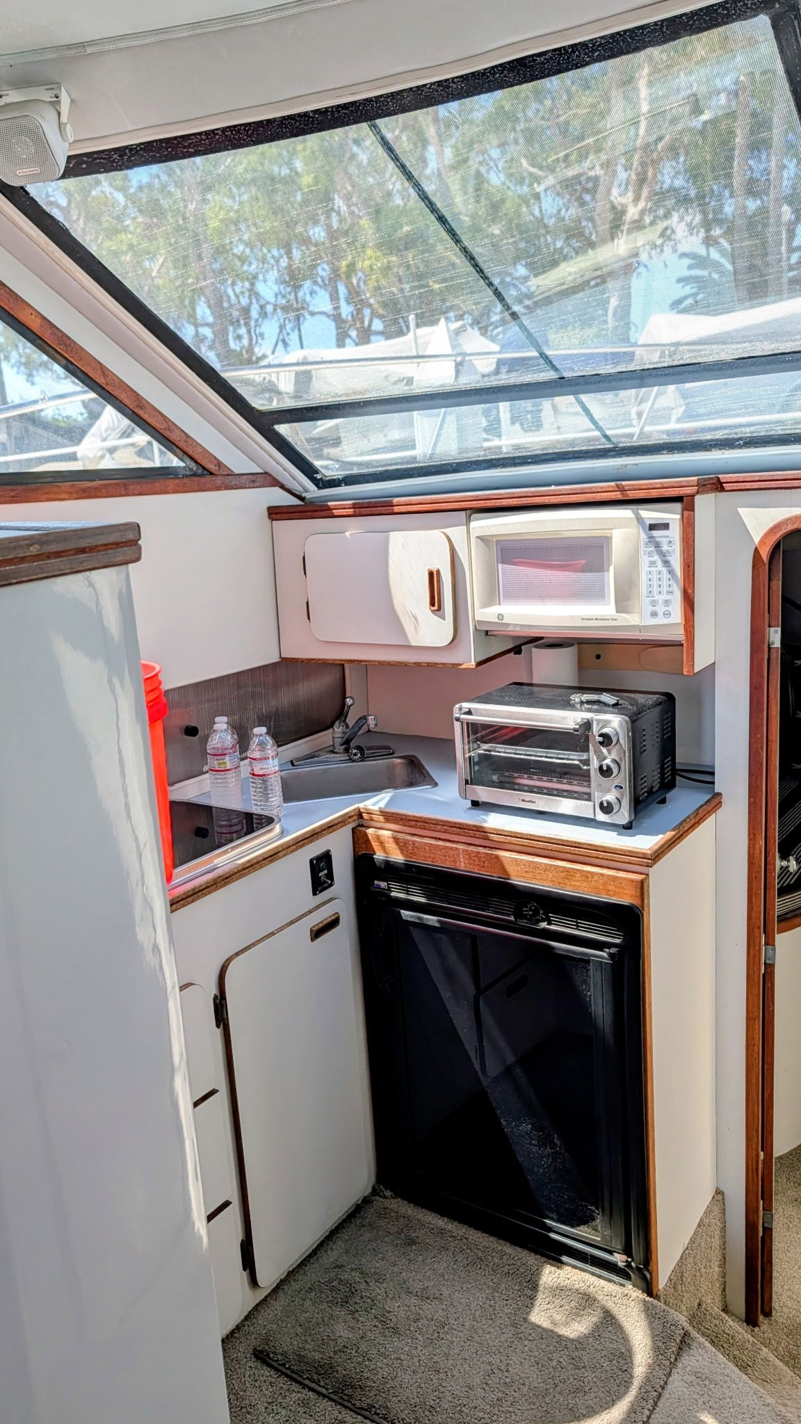 Interior of a 1987 Chris-Craft 320 Amerosport Express with kitchenette, microwave, and fridge.