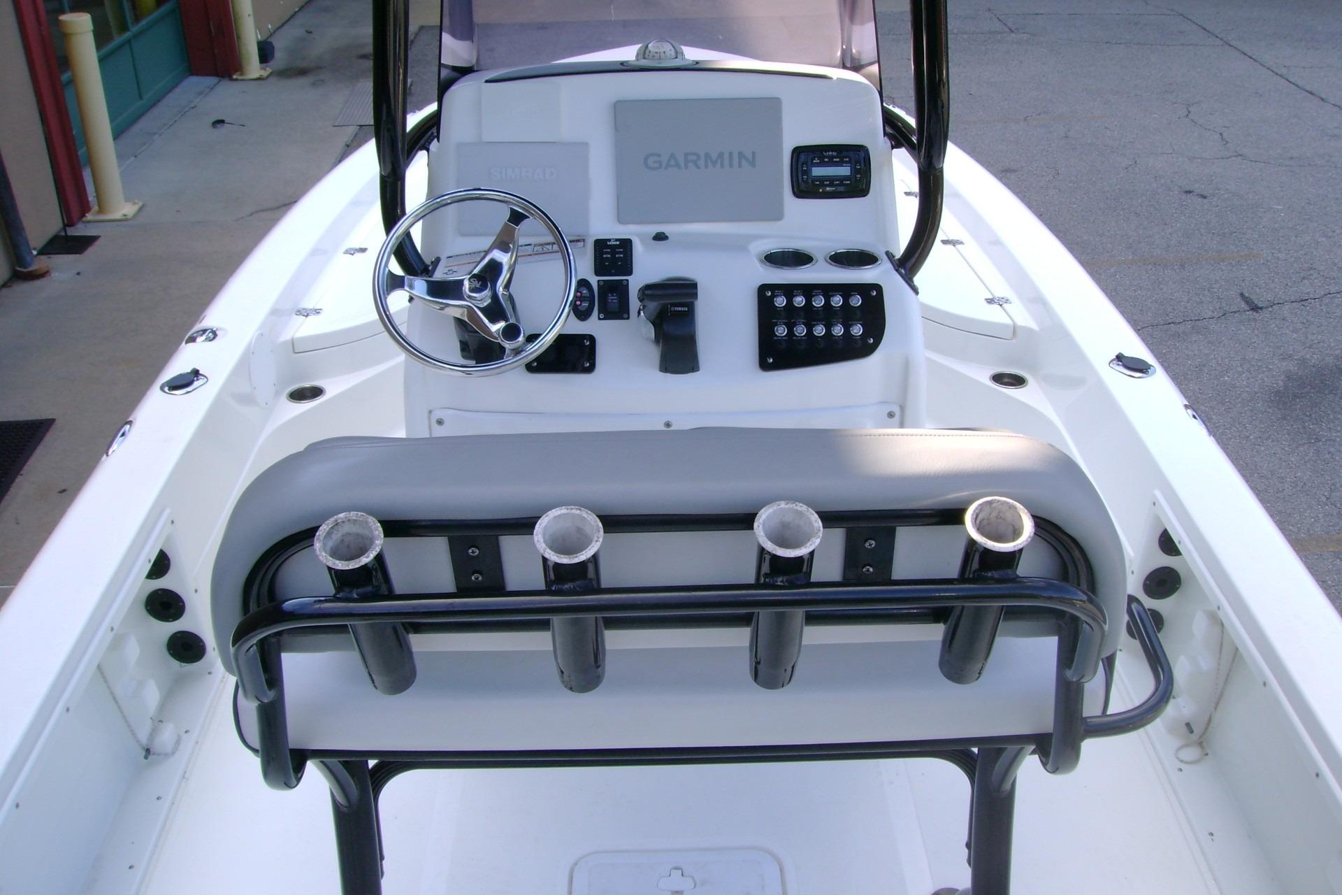 2022 NauticStar 227 XTS boat console with steering wheel and rod holders.