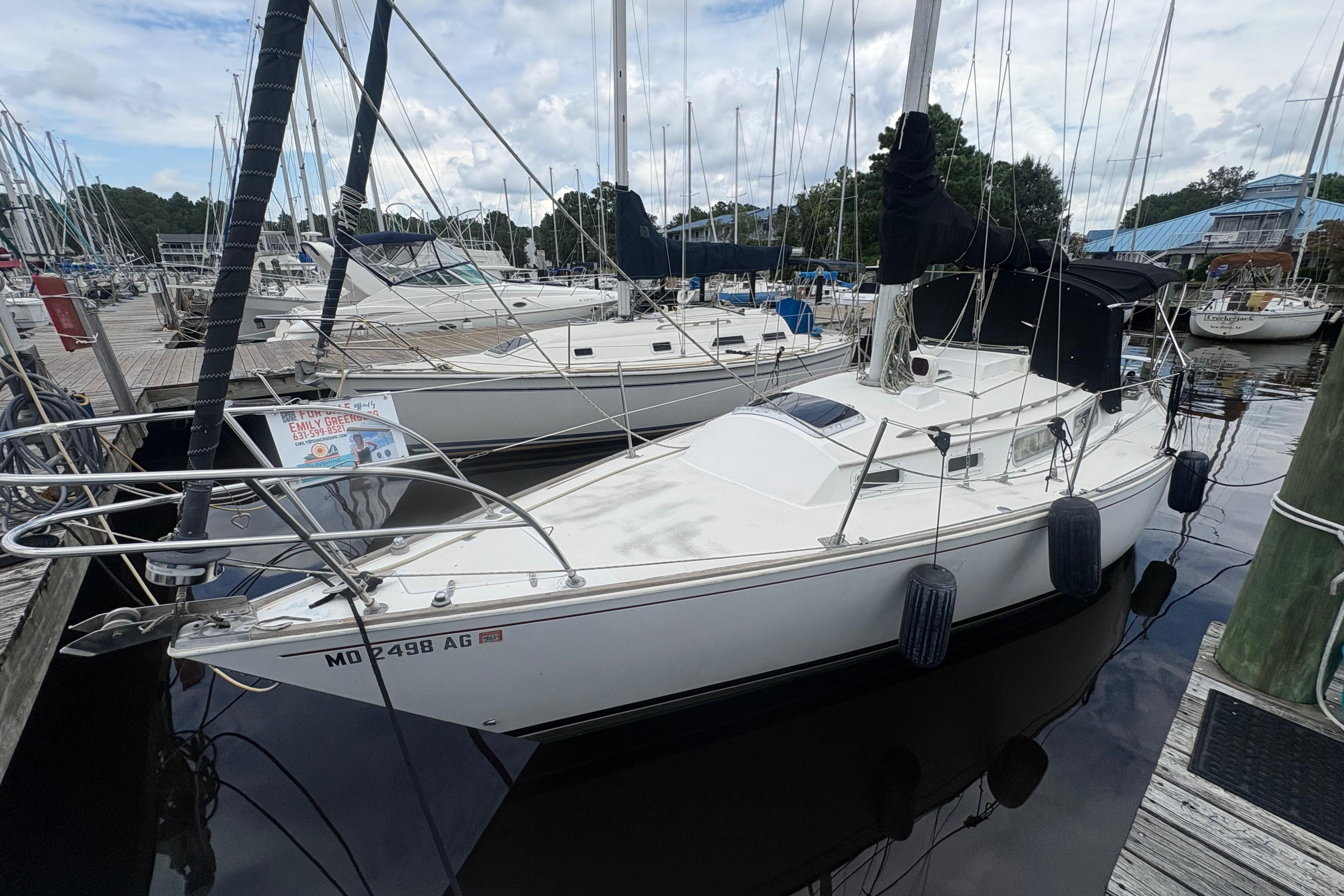 1981 Sabre 31 sailboat docked at marina, surrounded by other boats.