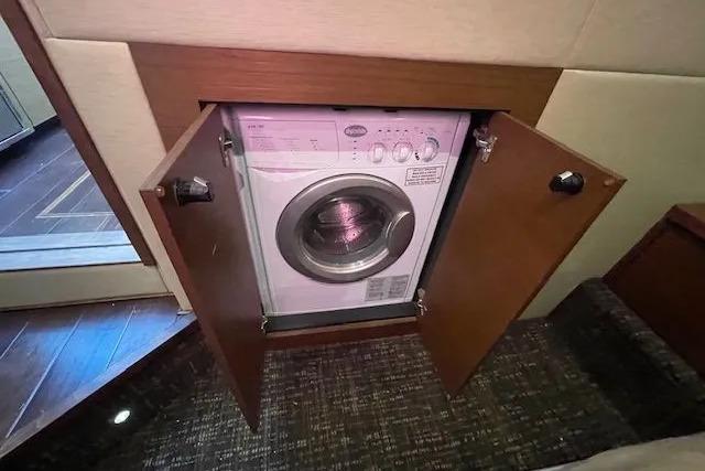 Built-in washing machine on 2016 Sea Ray Sundancer 510 yacht, behind wooden cabinet doors.