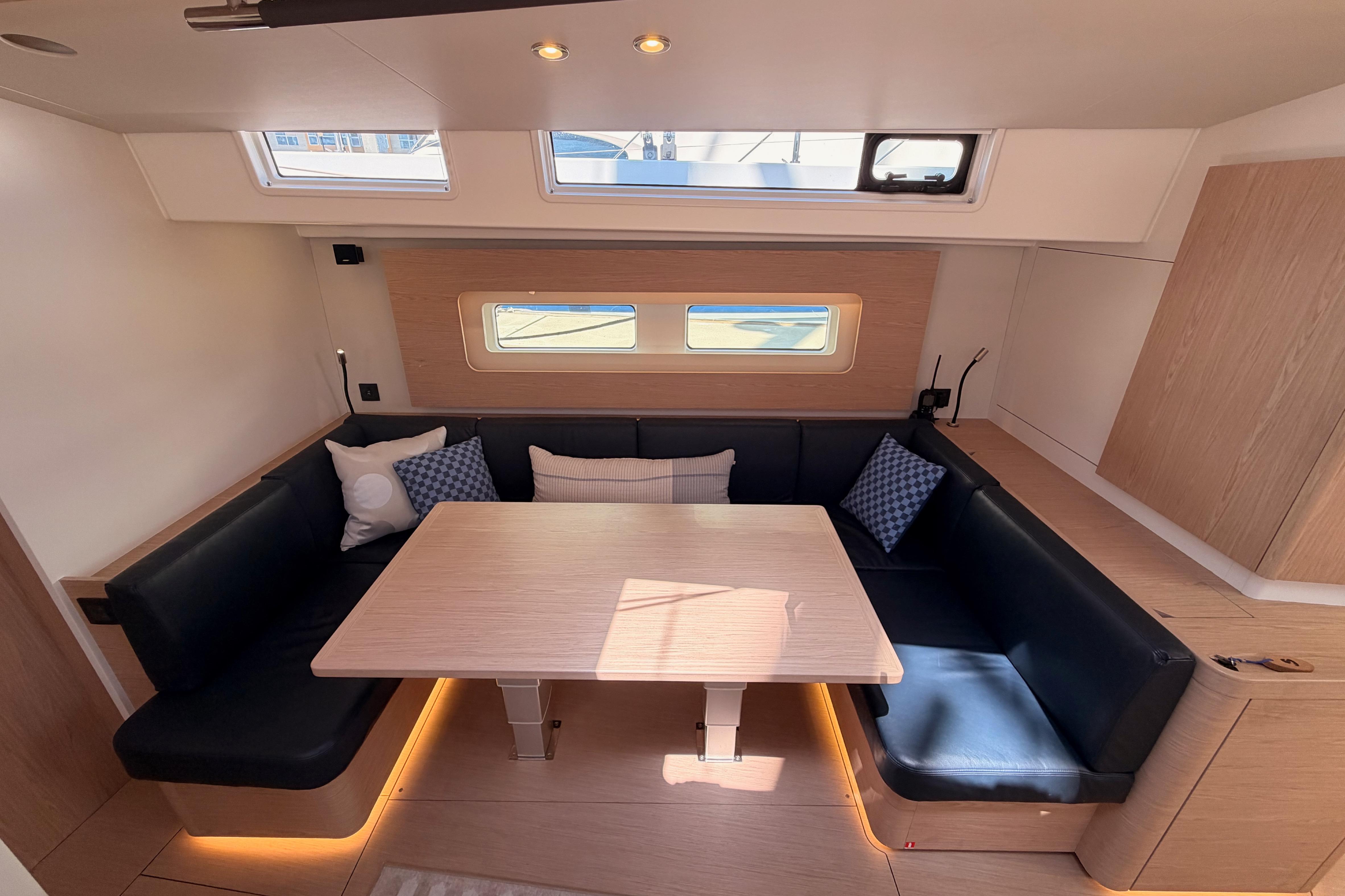 Interior of 2022 Beneteau Oceanis Yacht 54 with modern seating and dining area.