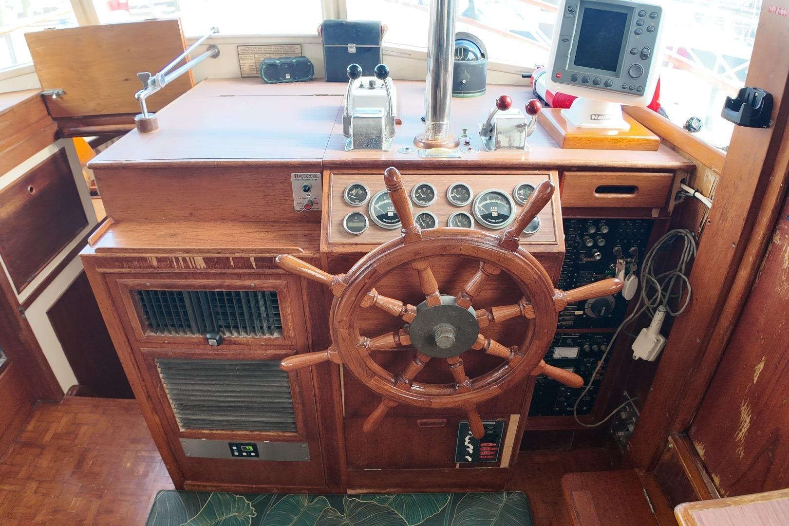 1978 Grand Banks 42 Classic helm with wooden wheel, gauges, and navigation equipment.