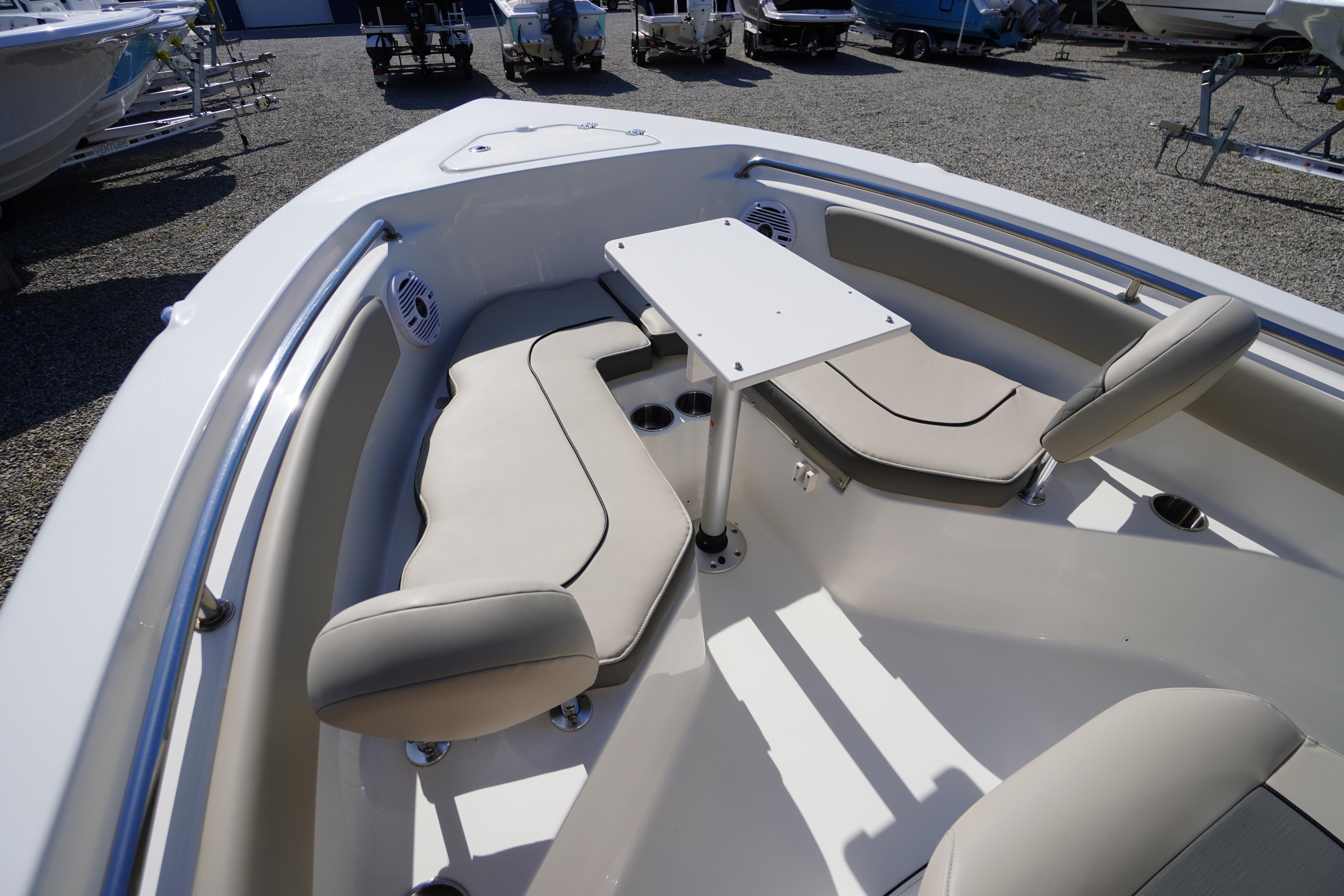 2025 Key West 203 FS boat interior with seating and table, displayed outdoors.