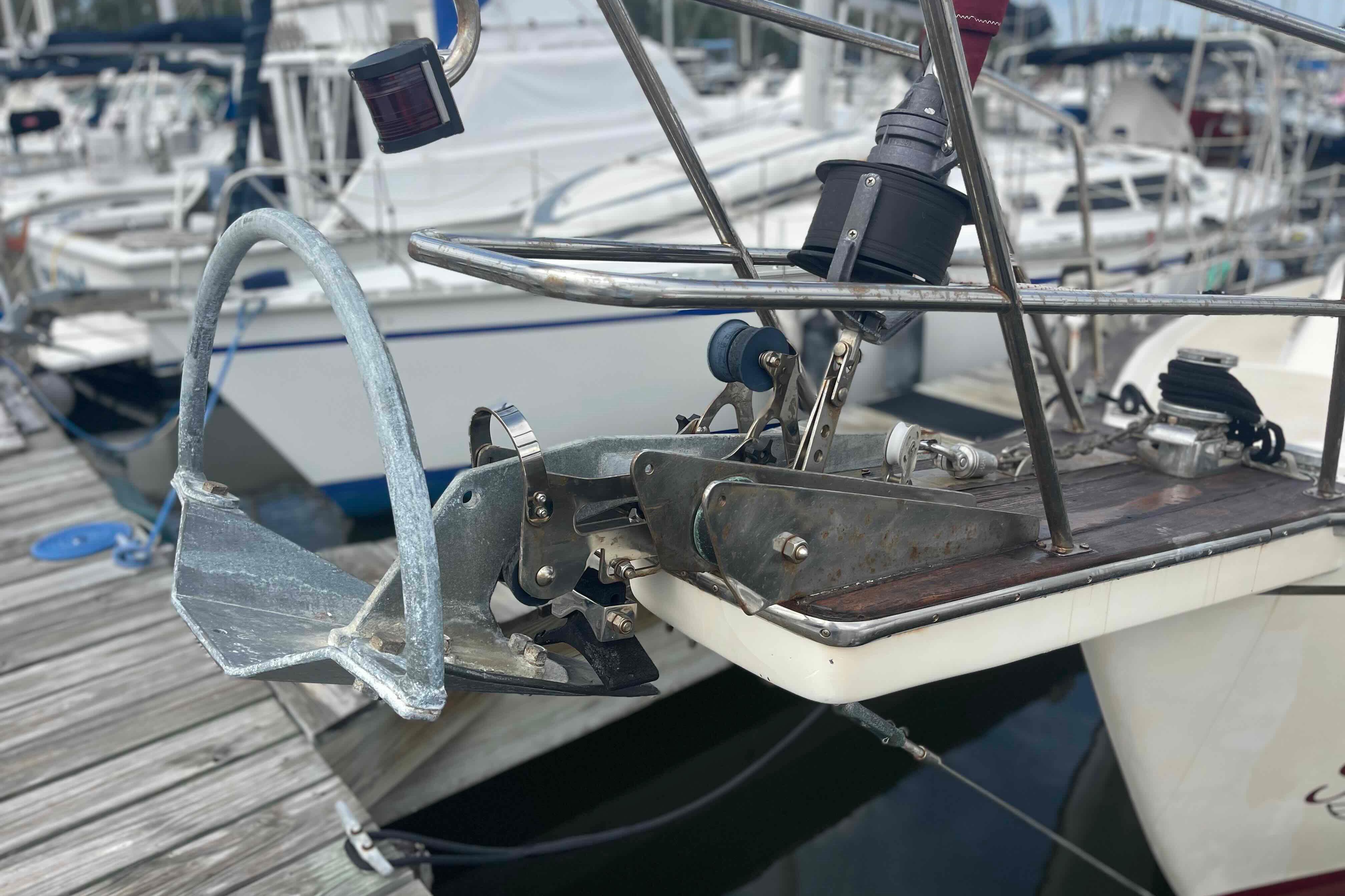 Bow of 1989 Island Packet 35 sailboat with anchor and winch at marina.
