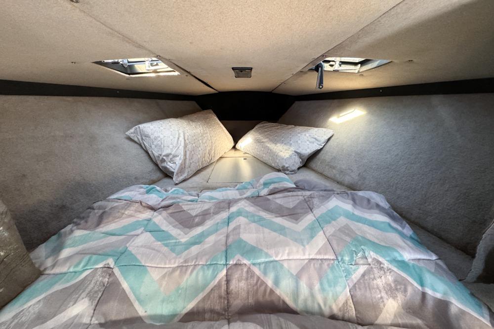 Cozy cabin interior of 1989 Formula 292 SR-1 with patterned bedding and pillows.
