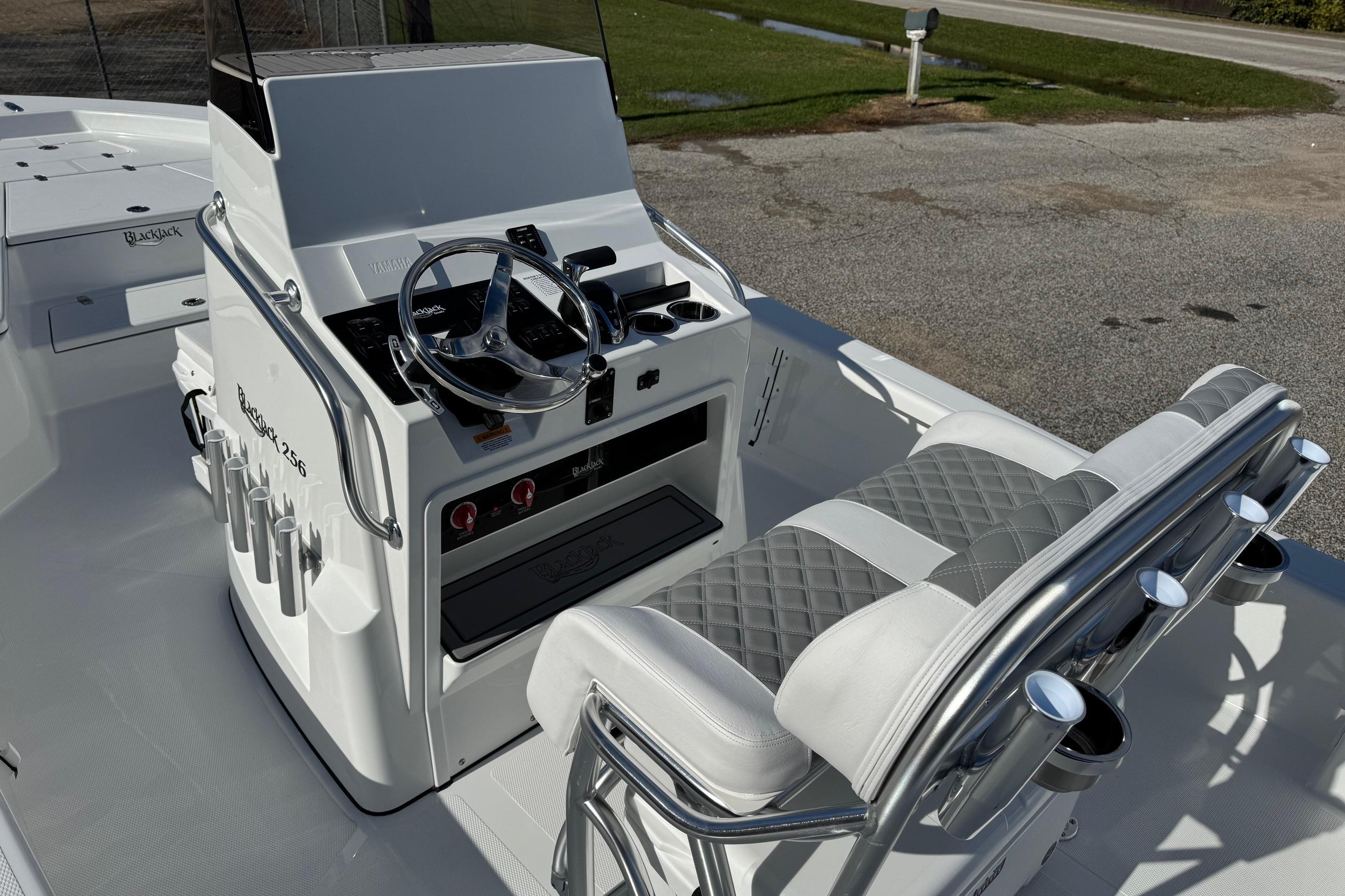 2026 BlackJack 256 Bay boat interior with steering console and cushioned seating.