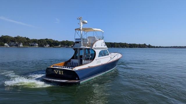 2007 Hinckley Talaria 44 Flybridge yacht cruising on a calm lake.