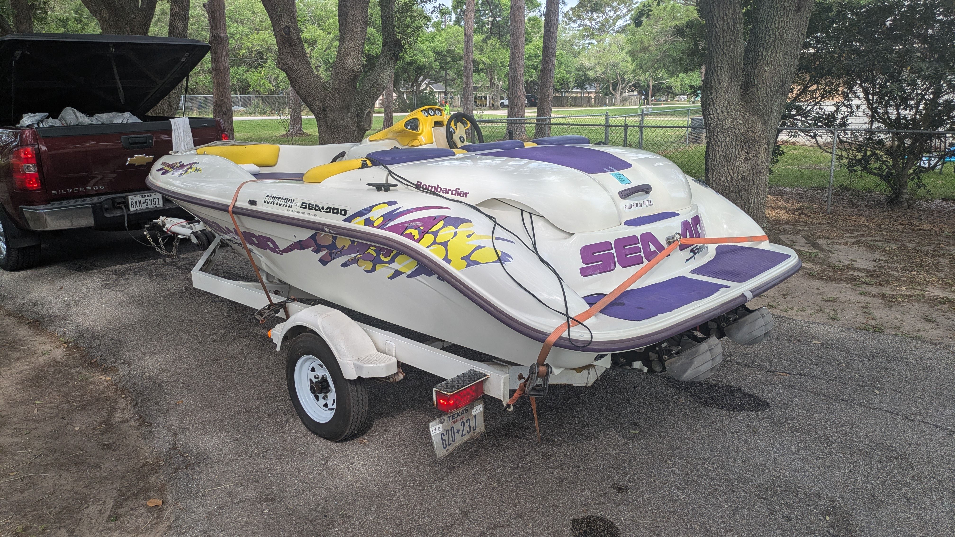 A 1995 Bombardier SeaDoo SPEEDSTER on a trailer, parked on a road next to a pickup truck.