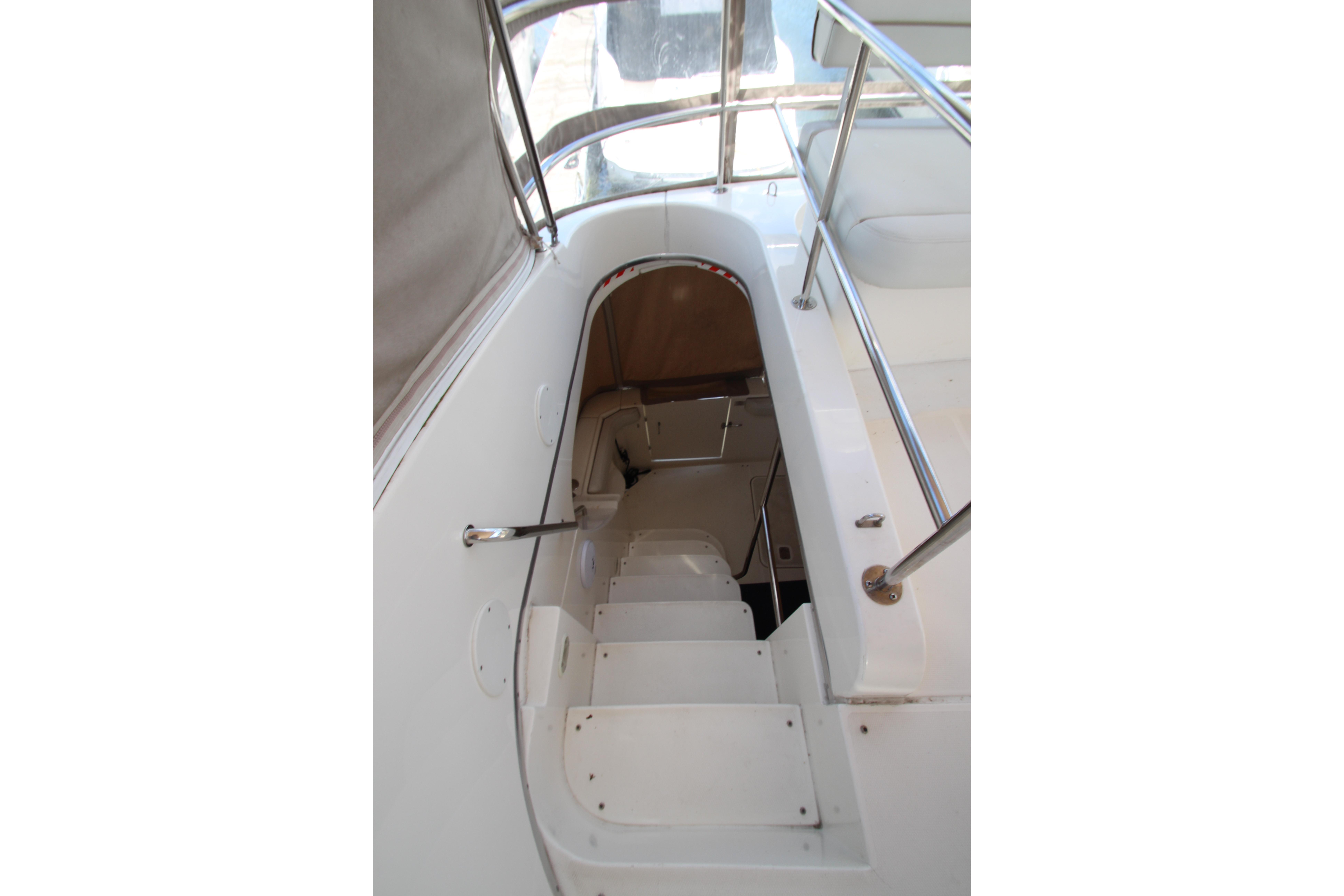 Staircase on 2006 Silverton 38 Sport Bridge yacht, featuring sleek white design and metal railings.