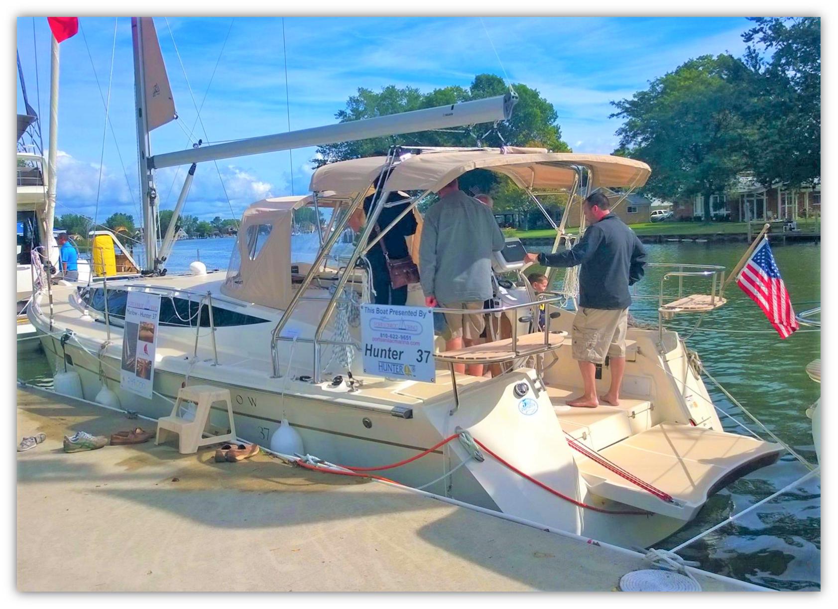 2015 Marlow-Hunter 37 sailboat docked, people onboard, American flag displayed, sunny day.