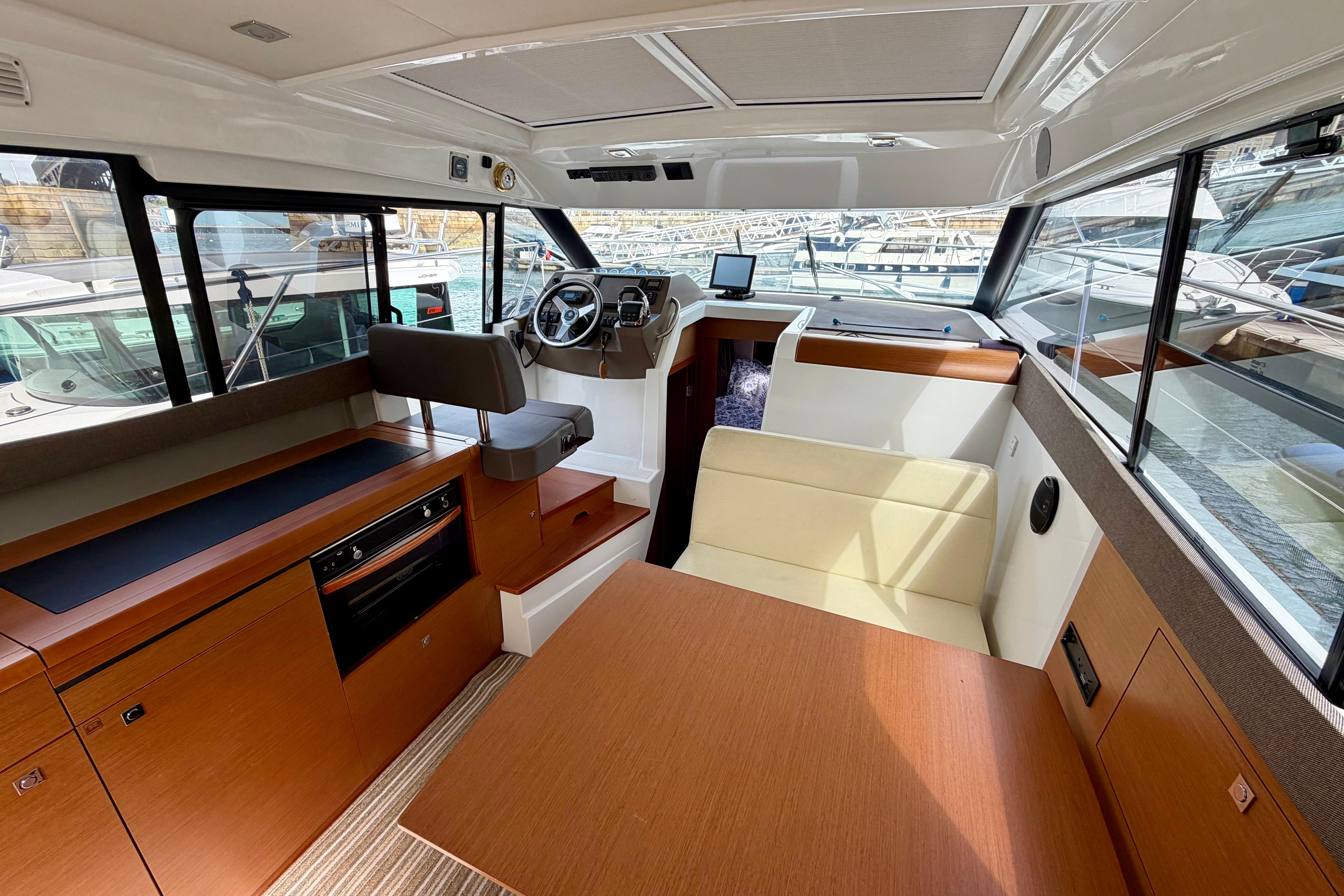 Interior of 2013 Jeanneau NC 9 boat with modern seating and navigation area.