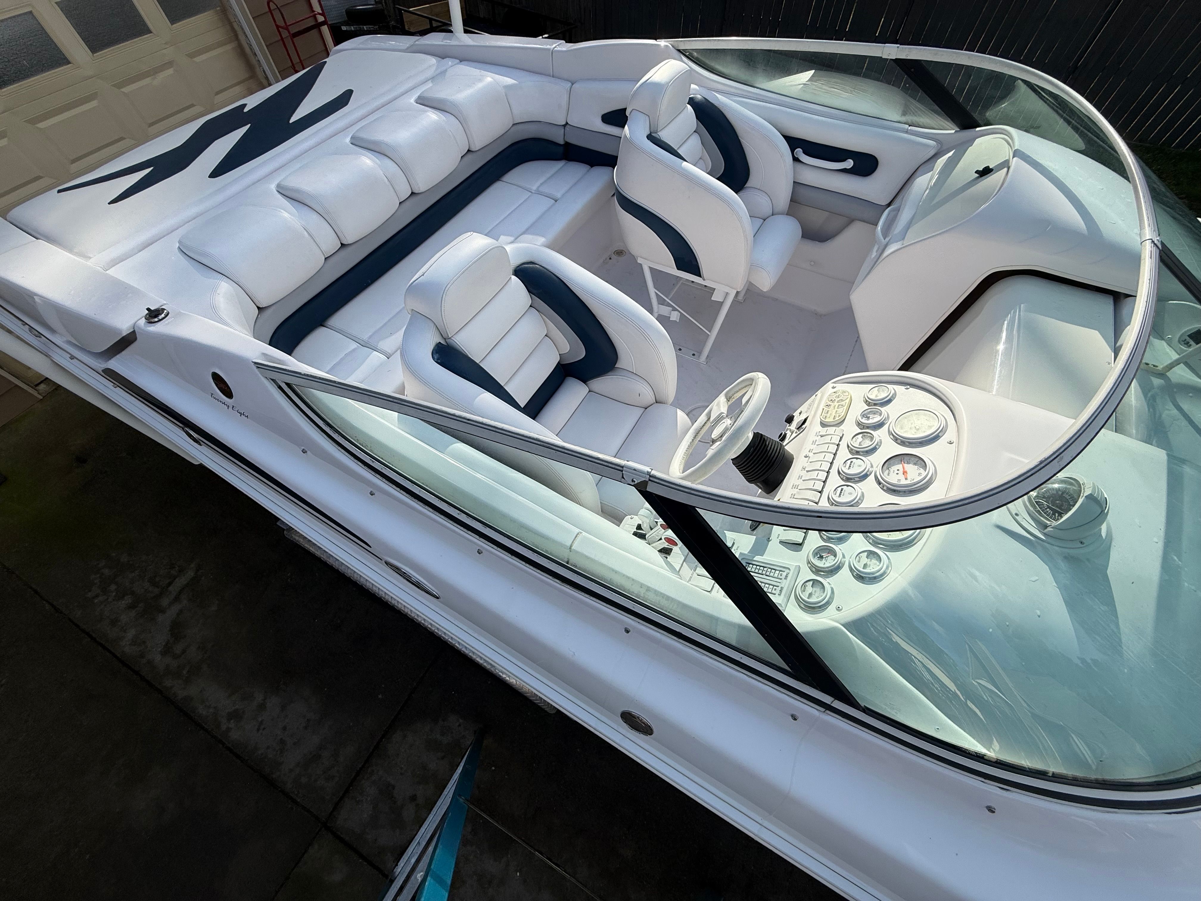The image shows the cockpit of a 2003 Donzi 28 ZX with white and blue seating.