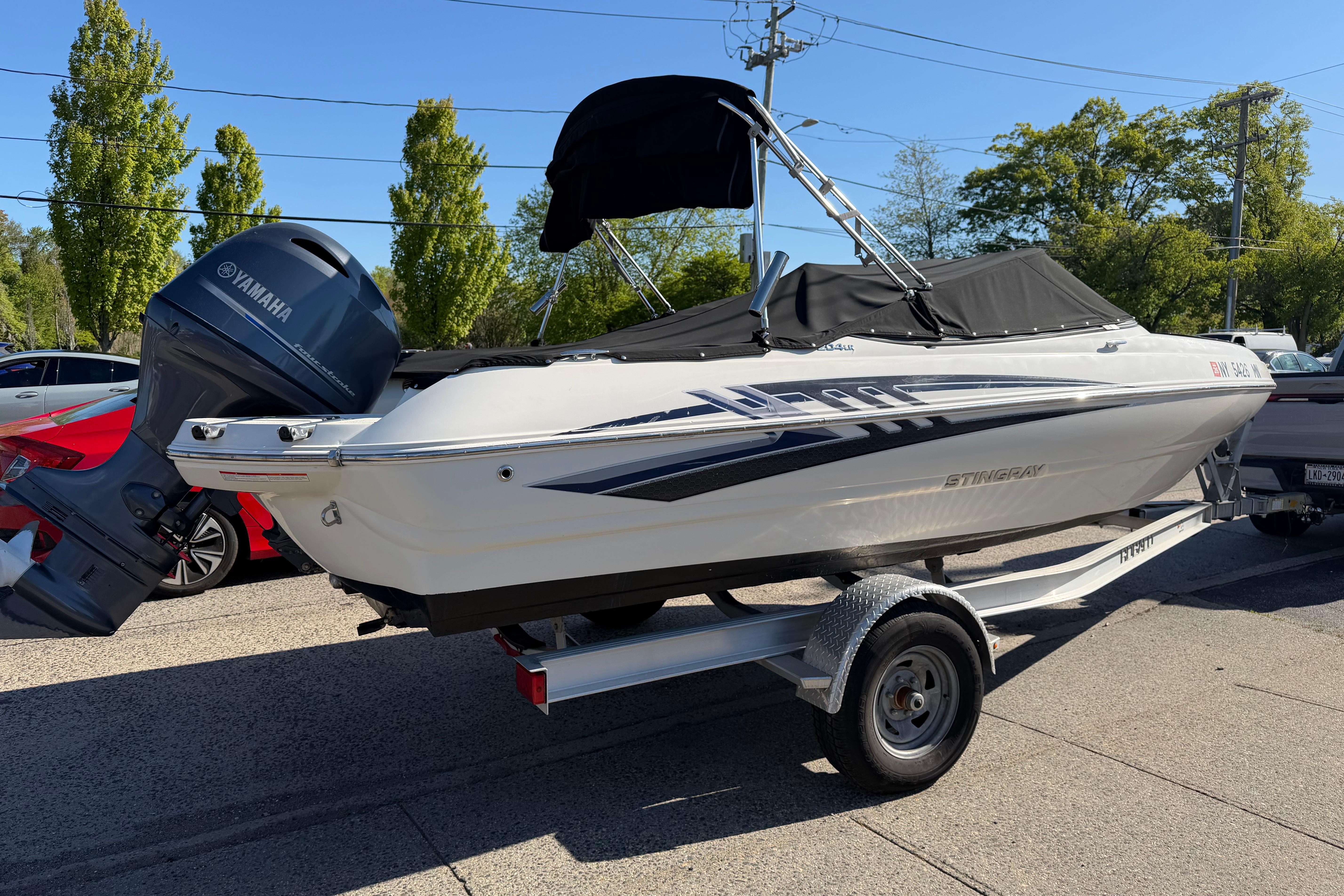 2018 Stingray 204 LR boat on trailer with Yamaha outboard motor, parked outdoors.