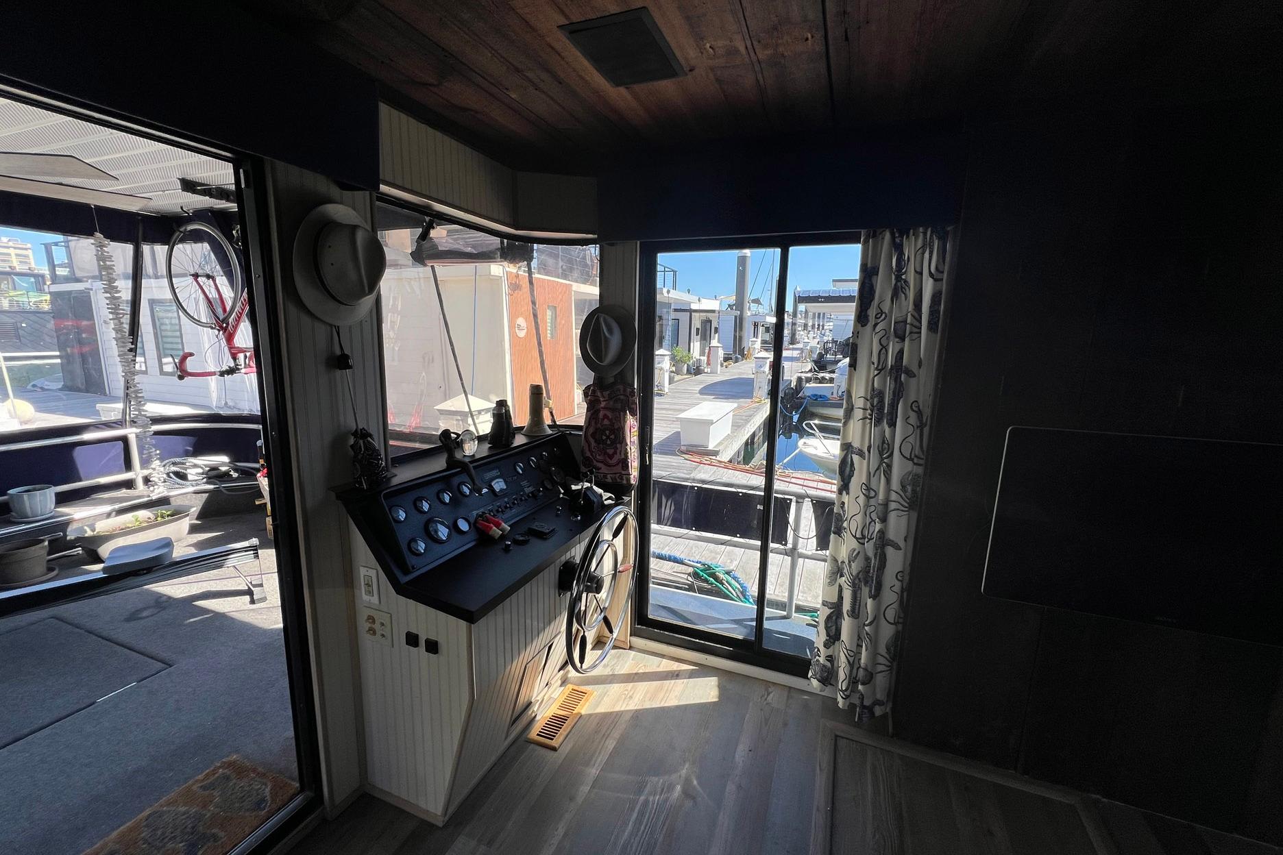 Interior view of a 1993 Sumerset houseboat with helm and marina view.