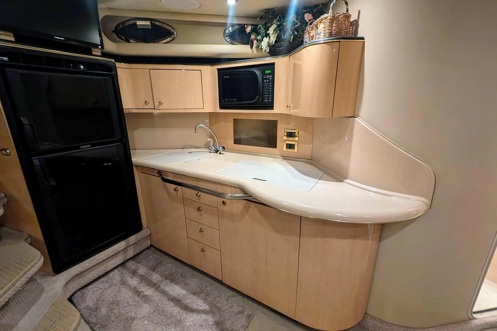 Interior of 2000 Sea Ray 380 Sundancer yacht kitchen with modern amenities.