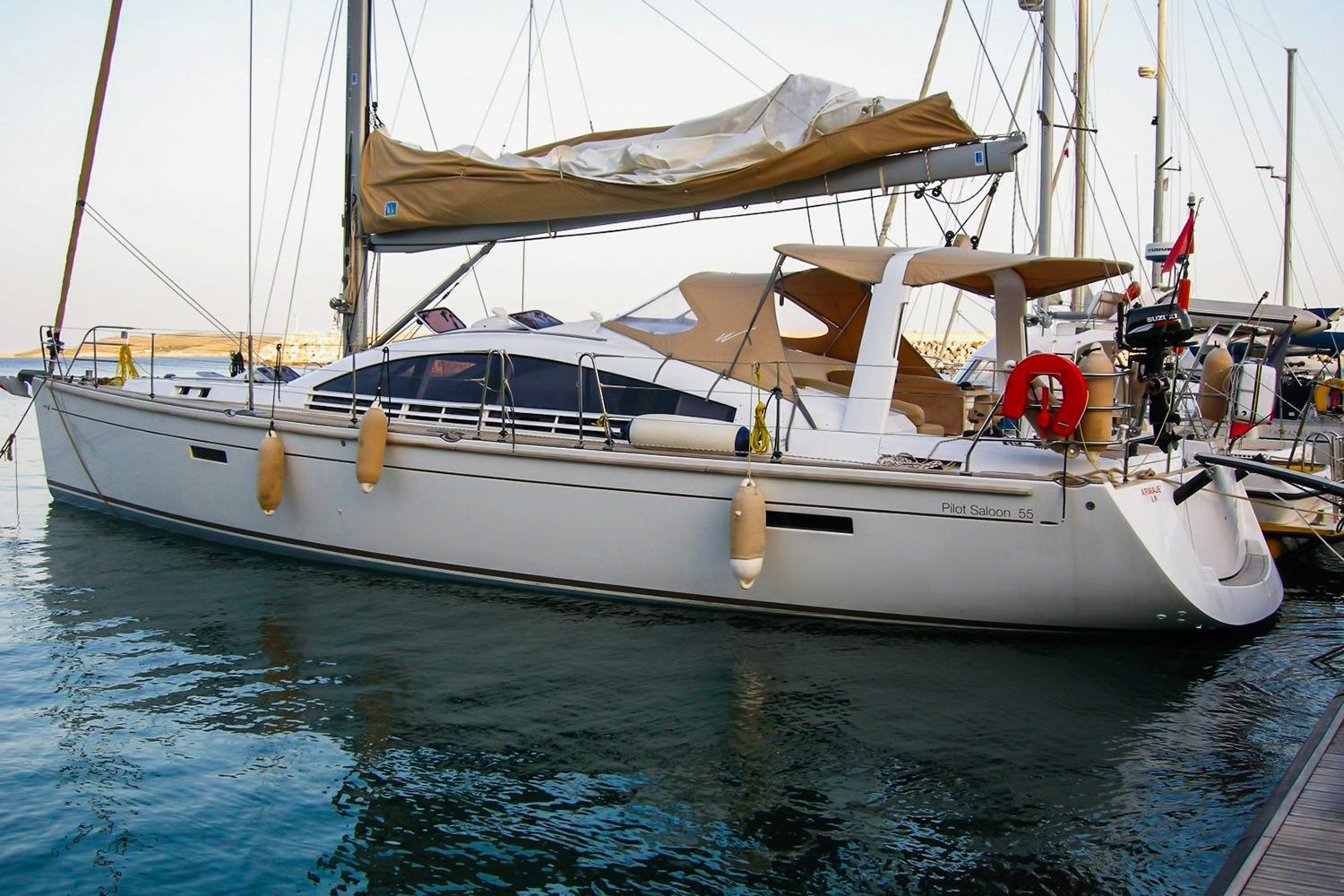 2008 Wauquiez Pilot Saloon 55 yacht docked in marina, featuring sleek design and beige canopy.