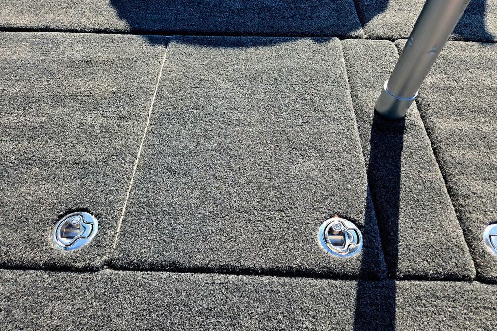 Carpeted deck of 2026 Skeeter ZXE20 boat with metal fixtures and pole.
