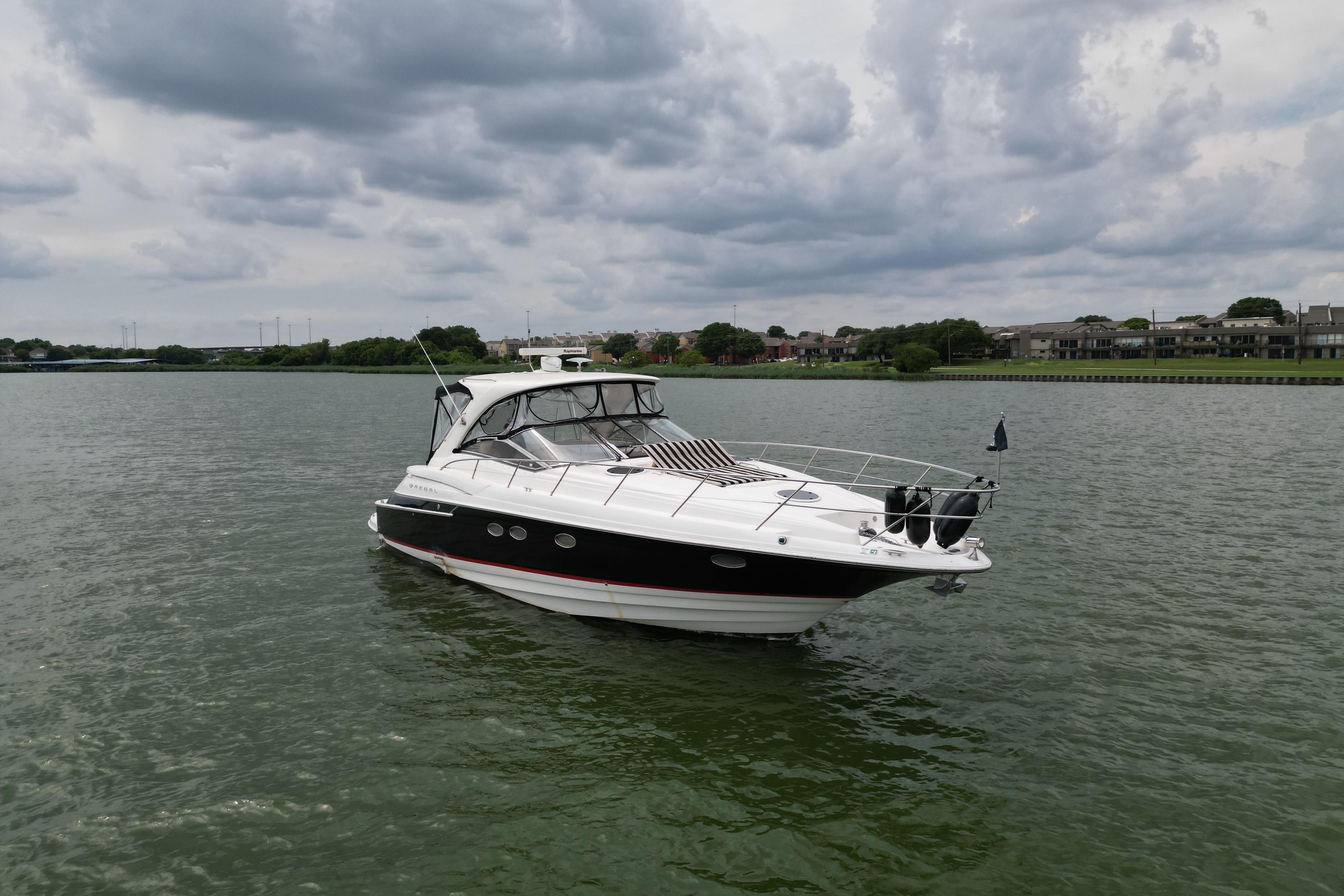 2005 Regal Commodore 4260 yacht on a calm lake under cloudy skies.