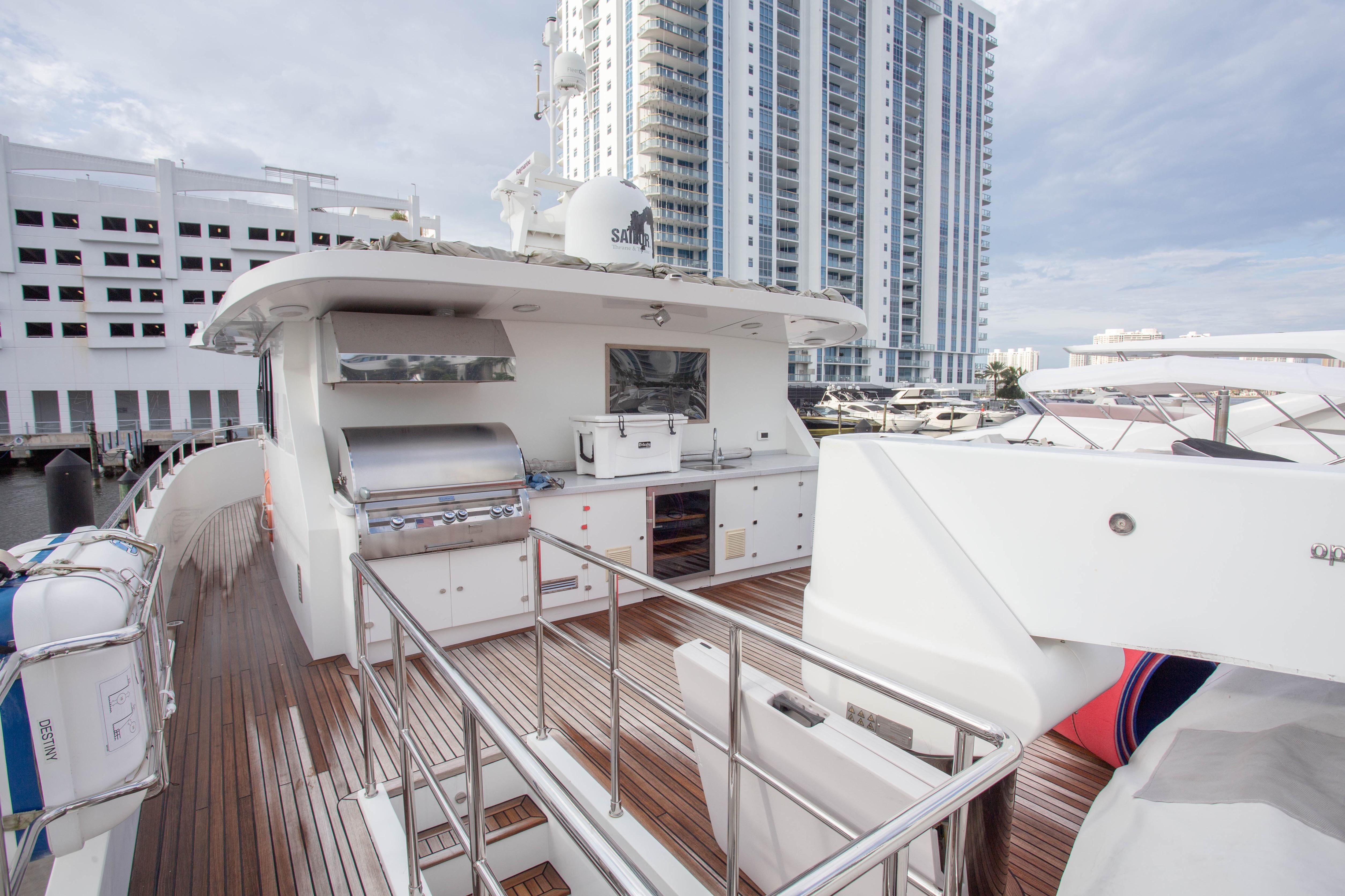 Luxurious 2014 Fifth Ocean Yachts 24m Explorer Yacht with outdoor kitchen and cityscape backdrop.