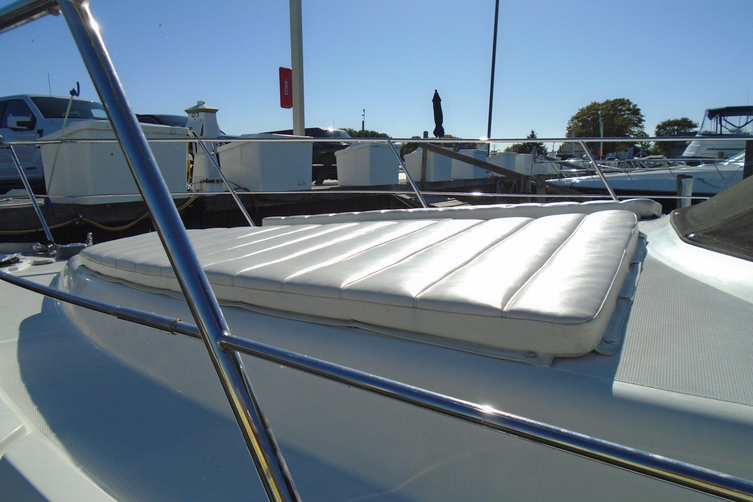 2004 Carver 356 Motor Yacht with sunpad, docked at marina under clear blue sky.